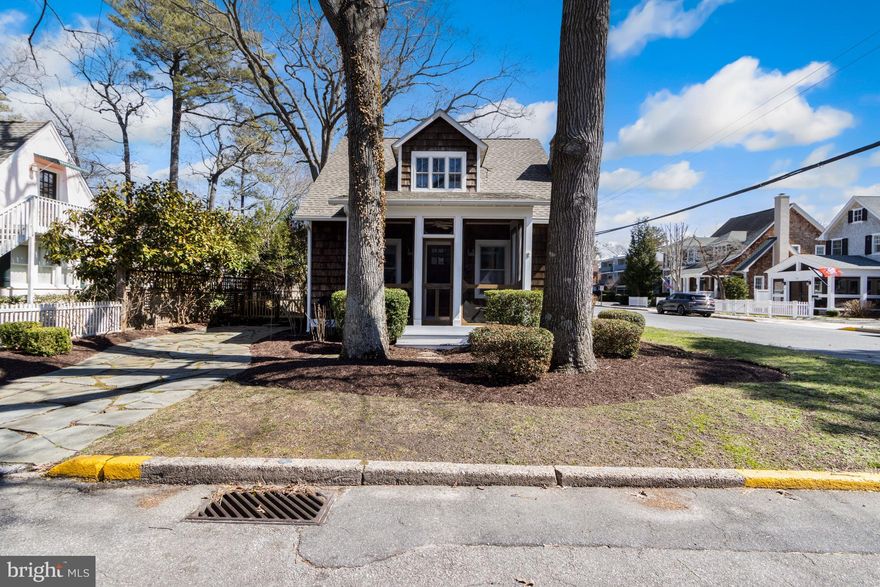 Blocks from the beach! Situated on a corner lot just a block from Rehoboth Avenue, 85 Sussex Street is a charming 3-bedroom, 2.5-bath coastal cottage. The front of the home offers excellent curb appeal with mature landscaping and a screened-in front porch. Enter through the front door into a living room with coastal blue walls, white wooden trim, and a gorgeous stone gas fireplace. The coastal blue-and-white palette flows into the connecting dining room, perfect for entertaining family and friends. Opening into the dining room, you’ll find a well-appointed kitchen with plenty of storage and counter space. The kitchen also features wooden cabinets, stainless steel appliances, tile backsplash, breakfast bar, and a door to the fenced-in backyard. Off the kitchen is a powder room. Come home from the beach to rinse off in the outside shower or sit and relax in your inviting backyard with a firepit for chillier nights. The first floor also features two comfortable bedrooms and a shared bathroom. Take the staircase to the second floor, which opens into a spacious master suite, with a flex space, perfect for an office or additional living area, as well as a large bedroom with built-in storage, a full bath, and a laundry area. Large windows are scattered throughout the home, showering each room with gorgeous natural light. A small balcony is off the back of the second floor, giving you the perfect place to relax with your favorite book at the end of the day. A long stone driveway provides off-street parking in the heart of downtown Rehoboth Beach. Whether you want to venture into town for a bite to eat at one of the city’s many restaurants, a shopping trip at the local boutiques, or take your pup to the local dog park, this home is perfectly positioned to live a laid-back life on the coast! Don’t miss your chance to call this beautiful Rehoboth Beach home yours. Schedule a private showing today!