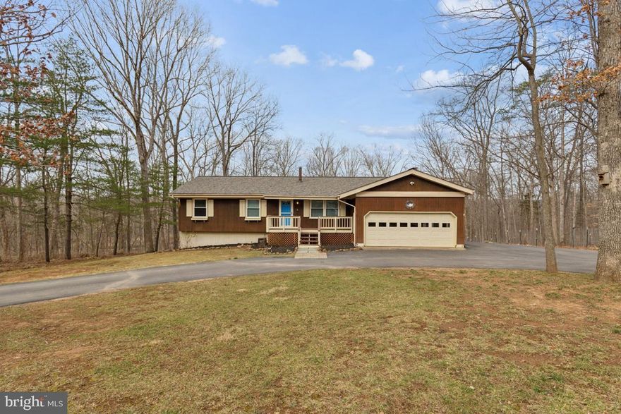 This light and bright five-bedroom three full bath rambler is nestled down in a private cul-de-sac on a one-and-a-half-acre wooded lot. This meticulously maintained home boasts a brand-new roof, fresh paint throughout and gleaming hardwood floors, creating an inviting atmosphere from the moment you step inside. The open-concept main level features a bright living room, dining area with custom chandelier and French doors to the rear deck and a modern kitchen with ceramic tile flooring, island bar seating with pendant lighting and Samsung stainless-steel appliances. Cozy up by the woodburning stove in the family room with large picture window overlooking the wooded rear yard or retreat to the primary suite with its gleaming hardwood floors and en-suite bath. Entertain effortlessly on the expansive front and rear decks and patios or around the fire pit in the side-yard graveled area.  The walk-out lower level is complete with recreation room, laundry, two additional bedrooms and a full hall bath. A horseshoe driveway, parking pad and attached two-car garage provide excellent parking for family and friends and the side-yard fenced coop offers the delightful opportunity to raise chickens for fresh eggs daily or the ability to house your choice of small livestock, be it goats or pigs. This home provides the perfect blend of comfort, privacy and outdoor living in a serene neighborhood setting!