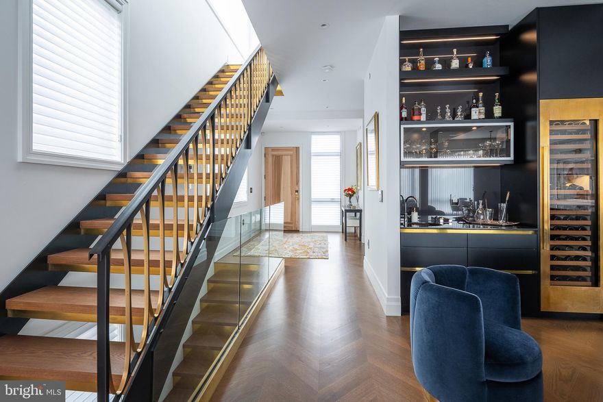 Welcome to 818 N 4th Street : Make your home among the city skyline in this elegant and chic custom penthouse with over 3,200 sq ft of living space and a 1,300 sq ft private roofdeck within a quiet boutique condominium in the heart of Northern Liberties. The unit also comes with 2-car parking in the building's attached temperature controlled garage. Low condo fees and 7 years remaining on the tax abatement ($2667/year). The home can be made available fully furnished for an additional fee (all furnishings were just recently purchased) making it turn-key ready! Acquired as an open, unfinished space, this sprawling home with 10-ft ceilings has been meticulously designed and crafted with the finest materials by its owner, the principal of a boutique design firm. Drawing inspiration from their world travels, the owners created a space that can host lavish dinner and cocktail parties as easily as casual barbecue movie nights on the rooftop deck. The oversized foyer entry opens to an expansive main level with a corner living room that takes advantage of the gorgeous bridge view and features a stunning custom stone entertainment center inlaid with brass. Relax in front of the gas fireplace while the solid oak chevron hardwood floors run underfoot and tall ceilings dotted with recessed lighting rise overhead. Designer light fixtures add chic style to the adjacent dining area, and a dramatic cocktail lounge ensures gracious hosting with a built-in wet bar and 102-bottle custom brass clad Sub-Zero wine refrigerator. Chefs will find their dream kitchen with its sleek custom cabinetry, top of the line Wolf and Miele appliances, enormous Dekton single slab center island, and dramatic full height Calcutta marble backsplash. A guest suite with a private full bath, stylish powder room and coat closet complete this luxurious entertaining level. A floating grand staircase carries you to the home's crowning glory -- an ultra private 1,300 sq ft roof deck with a commanding 360-degree view of the city skyline. Here, a full kitchen with Wolf and Sub-Zero appliances along with a 65" outdoor television welcome al fresco dining and lounging with the iconic city skyline as your backdrop. Head to the home's lower level to find tranquil private living quarters. The expansive owner's suite boasts two custom walk-in closets. No expense was spared in the 500 sq ft master bath with its floor to ceiling hand matched marble tile and Dornbracht fixtures. A huge shower, freestanding soaking tub, water closet and his and her vanities complete this incredible space. The spacious hallway opens to another guest bedroom, full hall bath with floor to ceiling marble and custom cabinetry, as well as a 4th bedroom currently being used as a media room. A well-equipped laundry room with ample storage add effortless ease to this impeccable, bespoke residence. Additional ample storage space is hidden away under the staircase. This home features extensive smart technology and home automation including Control4 with speakers throughout the residence, Nest thermostats and LeGrand custom lighting with WiFi control. Custom window treatments by Allure throughout the home are designed to allow for maximum light through the Eastern and Southern exposures while maintaining privacy for the owners. Located on a tree-lined block in Northern Liberties and ideally situated between Old City and Fishtown, this unrivaled home is surrounded by outstanding boutiques, restaurants and nightlife venues with The Piazza/Schmidt's Common within easy reach. Enjoy great community parks and gardens, including Liberty Lands and East Poplar Playground, and fantastic transportation options with the Spring Garden SEPTA station, ample bus service and the Delaware Expressway all nearby.