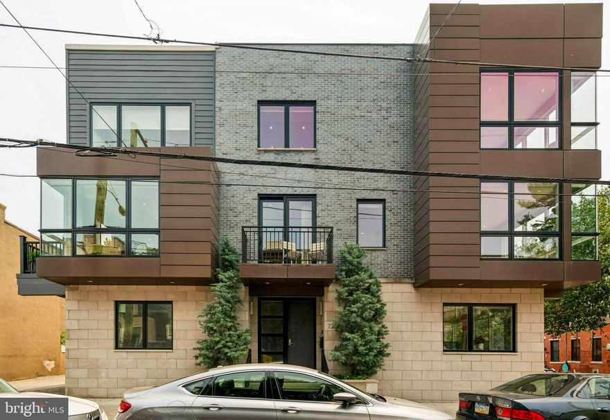 725 S 19th Street is a one-of-a-kind architectural masterpiece, with over 3,600 interior square feet of true modern elegance and 1,300+ square feet of exceptional outdoor spaces, all perfectly situated in the heart of Graduate Hospital.  Encompassing the entire northeast corner of 19th & Fitzwater Streets, this stunning home spans an extraordinary 71 feet wide, an extremely rare offering in Philadelphia. Designed with clean lines, expansive glass, and exceptional finishes, this residence blends luxury, function, and striking design in every detail.  The entry level welcomes you with a double-door foyer, a large coat closet, full bathroom, a spacious guest bedroom, and direct access to the oversized two-car garage. At the heart of the home is a dramatic steel & wood,  open-riser staircase crafted with 4-inch solid oak treads, anchoring the space with sculptural beauty. The second level is a showstopper, surrounded by windows on three sides, floor-to-ceiling glass, and striking glass corner walls that flood the space with natural light. The open living & dining area features a custom-designed three-sided glass fireplace with built-in entertainment center, all overlooking the tree-lined streetscape. The adjacent kitchen is a chef’s dream—with a custom oversized solid stone island with seating, it boasts Wolf, Sub-Zero, and Miele appliances, a Miele built-in coffee station, a three-basin sink, and expanded custom cabinetry that reaches to the ceiling and continues under the island. Two outdoor spaces, front balcony and a side deck, extend the living & entertaining options and offer the perfect place to start or end the day.  The next level is home to the impressive Primary Suite, offering a peaceful retreat w/corner gas wall-mounted fireplace framed by a marble mantle, a large walk-in closet plus two additional closets, and a spa-like ensuite bathroom. This luxurious bath includes a freestanding soaking tub, an oversized seamless glass shower w/triple over head showers & massage heads, and a private water closet.  The third bedroom with ensuite bath completes this level and includes a custom-built white pine & walnut wall-length closet system w/shelving adding additional storage. This room currently functions as a beautifully outfitted home office.  At the top of the home, you'll find a full pilot house with a kitchenette that opens onto an expansive roof deck finished with gorgeous porcelain tile pavers. From this elevated perch, enjoy spectacular panoramic views—sunrise to sunset and full skyline vistas from river to river—making it the ultimate space for entertaining & relaxing.  The fully finished lower level continues the home’s thoughtful design & functionality, featuring a built-in wet bar, wine storage, two beverage centers, and flexible space ideal for a home theater, pool table, gym, or family room. This space could also easily accommodate a 4th bedroom.  A large laundry room with built-in storage adds to the convenience on this level as well.  Located within walking distance to Rittenhouse Square, Avenue of the Arts, Schuylkill River Park & Trails, & easy access to 30th St Station, University City, I-76, and all the amenities of Center City.  Please join us this Sunday, June 15th for an Open House from 12 to 2 PM.  Extensive Improvement & Upgrade list available upon request.