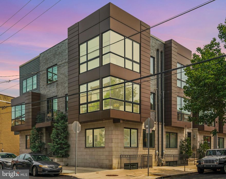 725 S 19th Street is a one-of-a-kind architectural masterpiece, with over 3,500 interior square feet of true modern elegance and 1,300+ square feet of exceptional outdoor spaces, all perfectly situated in the heart of Graduate Hospital.  Encompassing the entire northeast corner of 19th & Fitzwater Streets, this stunning home spans an extraordinary 71 feet wide, an extremely rare offering in Philadelphia. Designed with clean lines, expansive glass, and exceptional finishes, this residence blends luxury, function, and striking design in every detail.  The entry level welcomes you with a double-door foyer, a large coat closet, full bathroom, a spacious guest bedroom, and direct access to the oversized two-car garage. At the heart of the home is a dramatic steel & wood,  open-riser staircase crafted with 4-inch solid oak treads, anchoring the space with sculptural beauty. The second level is a showstopper, surrounded by windows on three sides, floor-to-ceiling glass, and striking glass corner walls that flood the space with natural light. The open living & dining area features a custom-designed three-sided glass fireplace with built-in entertainment center, all overlooking the tree-lined streetscape. The adjacent kitchen is a chef’s dream—with a custom oversized solid stone island with seating, it boasts Wolf, Sub-Zero, and Miele appliances, a Miele built-in coffee station, a three-basin sink, and expanded custom cabinetry that reaches to the ceiling and continues under the island. Two outdoor spaces, front balcony and a side deck, extend the living & entertaining options and offer the perfect place to start or end the day.  The next level is home to the impressive Primary Suite, offering a peaceful retreat w/corner gas wall-mounted fireplace framed by a marble mantle, a large walk-in closet plus two additional closets, and a spa-like ensuite bathroom. This luxurious bath includes a freestanding soaking tub, an oversized seamless glass shower w/triple over head showers & massage heads, and a private water closet.  The third bedroom with ensuite bath completes this level and includes a custom-built white pine & walnut wall-length closet system w/shelving adding additional storage. This room currently functions as a beautifully outfitted home office.  At the top of the home, you'll find a full pilot house with a kitchenette that opens onto an expansive roof deck finished with gorgeous porcelain tile pavers. From this elevated perch, enjoy spectacular panoramic views—sunrise to sunset and full skyline vistas from river to river—making it the ultimate space for entertaining & relaxing.  The fully finished lower level continues the home’s thoughtful design & functionality, featuring a built-in wet bar, wine storage, two beverage centers, and flexible space ideal for a home theater, pool table, gym, or family room. This space could also easily accommodate a 4th bedroom.  A large laundry room with built-in storage adds to the convenience on this level as well.  Located within walking distance to Rittenhouse Square, Avenue of the Arts, Schuylkill River Park & Trails, & easy access to 30th St Station, University City, I-76, and all the amenities of Center City.  Extensive Improvement & Upgrade list available upon request.
