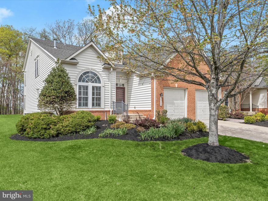 Step into this stunning end-unit townhome through a dramatic two-story foyer and living room, featuring soaring cathedral ceilings, gleaming hardwood floors, recessed lighting, expansive sun-filled windows, and a cozy corner gas fireplace. The formal dining room is rich with charm, offering hardwood floors, crown molding, a classic chair rail, and an elegant chandelier—perfect for entertaining. The gourmet kitchen is a chef’s dream, complete with granite countertops, a central island, double wall oven, and a spacious breakfast area framed by a wall of bright windows and direct access to a private, inviting deck. The main-level primary suite is a luxurious retreat, showcasing a stately tray ceiling, crown molding, a generous custom walk-in closet, and an en-suite bath with dual vanities and a sleek walk-in shower. A conveniently located powder room and laundry room complete the main floor. Upstairs, you’ll find a spacious office loft, two generously sized bedrooms with plush carpeting and custom closets, and a well-appointed full bath with a soaking tub. The finished lower level offers a large family room with a wet bar, a dedicated game area, a third full bath, and abundant storage space. Additional features include off-street parking via a one-car garage and private driveway. Residents of The Villages At Woodholme have access to a community clubhouse with a fitness center, sauna, and multipurpose gathering spaces. Outside, residents can enjoy a pool, patio, tennis courts, putting green, parks and natural spaces, and walking and biking trails.