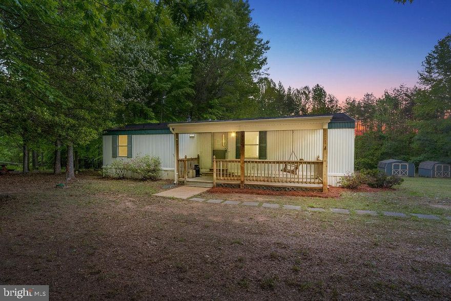 Discover the charm of this inviting 2-bedroom, 1-bathroom manufactured home, nestled on a generous 2-acre lot in Spotsylvania, VA. Built in 2003, this home offers a perfect blend of comfort and functionality. Step inside to find a cozy living space featuring new carpet and flooring and a seamless flow between the kitchen, dining, and living areas. The well-appointed kitchen comes equipped with essential appliances, including an electric oven/range, refrigerator making daily living a breeze. The bathroom features a convenient tub shower combination, providing a relaxing retreat after a long day. Outside, enjoy the serenity of nature from your screened deck, perfect for morning coffee or evening gatherings. The property also includes a detached carport with space for two vehicles and a gravel driveway for easy access. Two handy sheds offer additional storage for tools and outdoor equipment. This home is not just a place to live; it's a sanctuary where you can unwind and create lasting memories. With ample outdoor space and a warm, inviting interior, this property is ready to welcome you home. Don't miss the opportunity to make this charming residence your own!