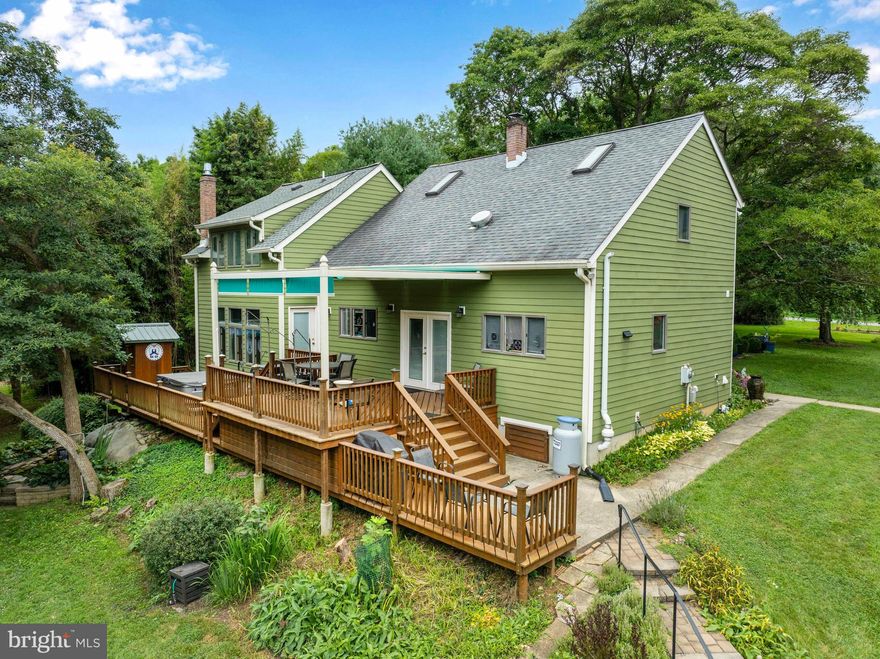 Nestled on a private lot in the serene Oakleigh subdivision, this charming contemporary home offers a perfect blend of lifestyle and functionality.  Set on three acres with several outbuildings, including a greenhouse, the expansive garden beds, babbling koi pond, and colorful foliage spread across the property are simply beautiful.  The home features four spacious bedrooms and three full bathrooms, highlighted by refinished hardwood floors that flow seamlessly throughout the main living areas.  The welcoming kitchen and dining spaces are perfect for gatherings and adjoin the large deck to extend the entertainment options to the outdoors, where enjoying a 5-person hot tub and an outdoor steam spa can be an every day occurrence.  Preferring a cozy fireplace, then settle into the large family room that has separate seating areas to serve a flexible lifestyle, or the walkout basement for a quiet retreat that's ideal for a hobby room.  There is an accommodating entry-level bedroom that is great for guests or as a home office, and the full bathroom on the main floor adds further versatility.  Each of the bathrooms are well-appointed, with a mix of stall and tub showers to suit each preference.  With a lengthy list of updates and upgrades across the years, this home has been lovingly maintained and is move-in ready.