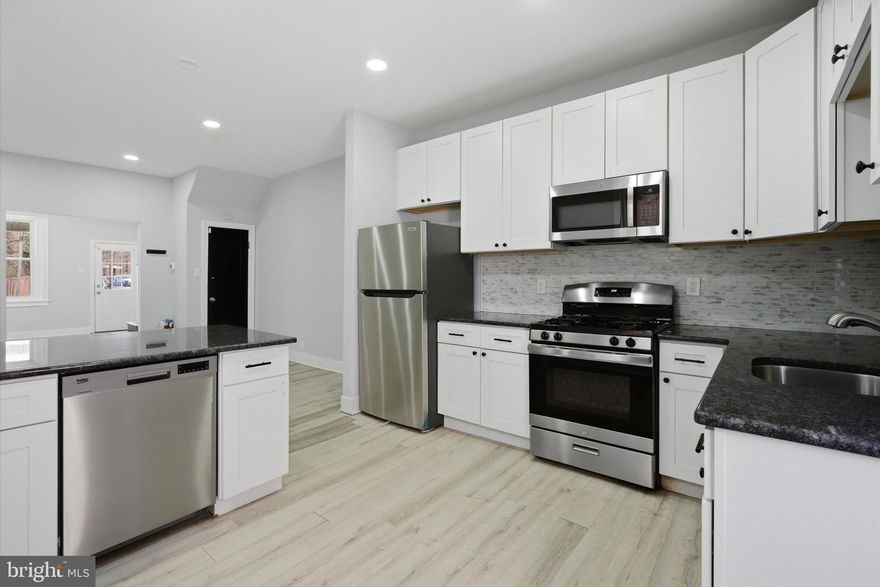 Step into this beautifully renovated 3-bedroom, 1.5-bath brick rowhome offering a perfect blend of modern updates and everyday functionality. 2041 Church Ln is move-in ready and thoughtfully designed for comfortable living. A welcoming front porch leads into a bright, open-concept main level featuring luxury vinyl plank flooring, recessed lighting, and a seamless flow between the living and dining areas ideal for both relaxing and entertaining. The updated kitchen is equipped with wood cabinetry, granite countertops, stainless steel appliances, and flexible space for an island or additional seating. A convenient half bath completes the first floor. Upstairs, you’ll find three well-sized bedrooms with great natural light and ample closet space, along with a tastefully updated full bathroom.  The basement is clean and dry, offering excellent storage or potential for future finishing. Out back, a private concrete patio provides the perfect space for outdoor gatherings or quiet evenings.  On-street parking is readily available. With its updated features and functional layout, this home is ready for its next owner.