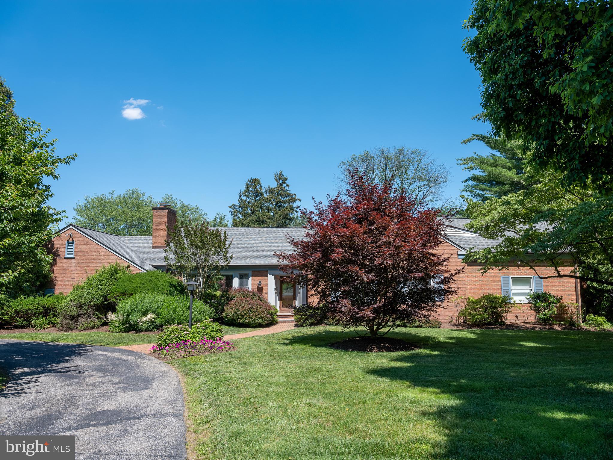 Custom designed and filled with natural light, this sprawling six bedroom mansion offers incredible entertaining spaces and a picturesque backyard retreat. From its lush landscaping to its beautiful brick facade, the home’s exterior is surrounded by exquisite outdoor areas including a quaint back patio, a spacious deck, a garden with a koi pond, and a lavish in-ground pool with a hot tub and lounging space. Enter through the front door into a bright and airy main level showcasing hardwood floors, intricate moldings, recessed lighting, and neutral paint. A sleek living room with an ornate fireplace sits adjacent to the formal dining room boasting walls of windows and glass doors that open to the large deck. Perhaps the most lavish aspect of this home is the timeless eat-in kitchen with white cabinetry, crisp countertops, a Kohler industrial sink, and high-end appliances, including a Viking two-tier oven, SubZero fridge, Bosch dishwasher, built-in KitchenAid trash can, and more. The adjacent breakfast nook features vistas of the yard and access to the patio, perfect for enjoying your coffee each morning. Truly luxurious, the expansive first floor primary suite has wonderful custom-built closets, oversized windows, an adjoining home-office, and a spa-like bath with dual sinks, a soaking tub, and a stall shower. An additional guest suite can be found on the main level overlooking the luscious backyard. Four sun-soaked guest bedrooms with cathedral ceilings, two bathrooms, and an additional home-office area can be found on the second level. Providing ultimate recreation space, the walk-out lower level enjoys a dance studio, woodshop, wet-bar, kitchenette, laundry area, full bathroom, ample storage, and doors that lead to the outdoor pool area. There is an attached two-car garage accessible via the dining room, mudroom, and patio area. With rooms designed to exceed today’s standards for living, working, and entertaining, 1615 Riverview Road is exceptional in every way possible. The property’s superb Gladwyne location is minutes away from Kenealy Nature Park, Henry Lane Park, Rolling Hill Park, and the Philadelphia Country Club. Conveniently close to excellent schools and local businesses, don’t wait to make this Main Line house your next home.