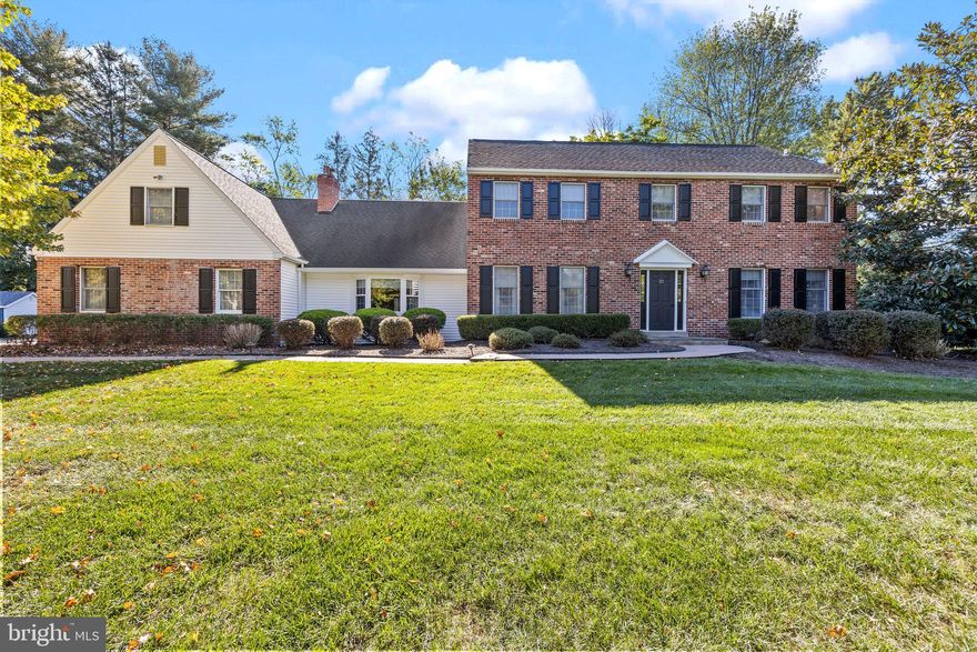 Welcome to 21 Shady Springs Drive in Doylestown — a beautifully maintained brick colonial that blends timeless style, thoughtful updates, and comfortable living across more than 3,900 square feet. Set on just over an acre of landscaped property, this five-bedroom, four-bath home offers space to unwind, entertain, and enjoy every season.

From the moment you arrive, the stately curb appeal and gently sloping front lawn make a lasting impression. Step inside to a spacious foyer that leads to formal living and dining rooms, both filled with natural light. The kitchen is a true centerpiece — featuring granite countertops, a large island, and warm wood cabinetry. It opens seamlessly to the step-down family room, where beamed ceilings, custom built-ins, and a brick fireplace create a cozy gathering space with character.

Just beyond, a screened-in sunroom overlooks the in-ground pool and private, fenced backyard surrounded by mature trees — the perfect spot for summer relaxation or hosting friends. The first floor also includes a dedicated office, a full bath, and a convenient laundry area.

Upstairs, the master suite offers a peaceful retreat with a newly updated bathroom showcasing modern finishes and a sleek double vanity. Four additional bedrooms provide flexibility for guests, hobbies, or home office space, along with two more full baths. The finished basement adds even more living area, a full bath, and plenty of storage.

Hardwood floors in the foyer and kitchen, an attached two-car garage, and thoughtful updates throughout make this home move-in ready. And when it comes to location, it’s hard to beat — close to Doylestown’s shops, restaurants, cultural spots and top-rated local amenities.  Local access to the Doylestown Septa station, routes 611, 202, and 263 make exploring the everything from the suburbs to the city within reach.

This is a home where classic design meets everyday comfort — all in a setting that’s both private and convenient. Come see why 21 Shady Springs Drive stands out as a truly special Doylestown property.