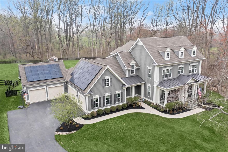 Welcome to 12240 Pleasant Springs Court - a premier offering in the exclusive enclave of Highland Reserve. Built in 2018, this Hawthorne model crafted by acclaimed home builder Mitchell & Best boasts 5 bedrooms, 4.5 bathrooms and more than 6,200 total square feet of refined living space. Sited on a fully-fenced picturesque one-acre lot with a breathtaking wooded backdrop, yet just minutes from the modern conveniences of Maple Lawn - this property presents a rare opportunity for privacy coupled with the most ideal and coveted location in Howard County. Parking will never be a problem with a five-car garage and lifts allowing for up to seven vehicles. Owned solar panels make for greatly reduced energy bills, and a custom playground and storage shed are already waiting for the kids in the backyard. 

The interior is as functional as it is elegant offering plantation shutters and wide-plank hardwood flooring throughout. The designer kitchen with all the most up-to-date accoutrements features light grey shaker-style cabinetry. The coffered ceiling and gas fireplace in the living room make it the heart of the home, while the eat-in breakfast nook leads to the TREX deck outside. More plantation shutters and hardwood flooring await on the upper level where you’ll find a sprawling primary suite offering a wall of windows and an expansive walk-in closet. The primary bath boasts two vanities, a soaking tub, and a spacious shower stall. Two of the secondary upstairs bedrooms share a bathroom while the third bedroom has an en suite bath all its own. The walk-out lower level boasts a custom wet-bar in the main recreation room, fully loaded home gym, large play room, guest room, full bathroom, and French doors leading to the paver patio outside. Don’t miss your chance to own one of the finest residences to become available in Howard County.