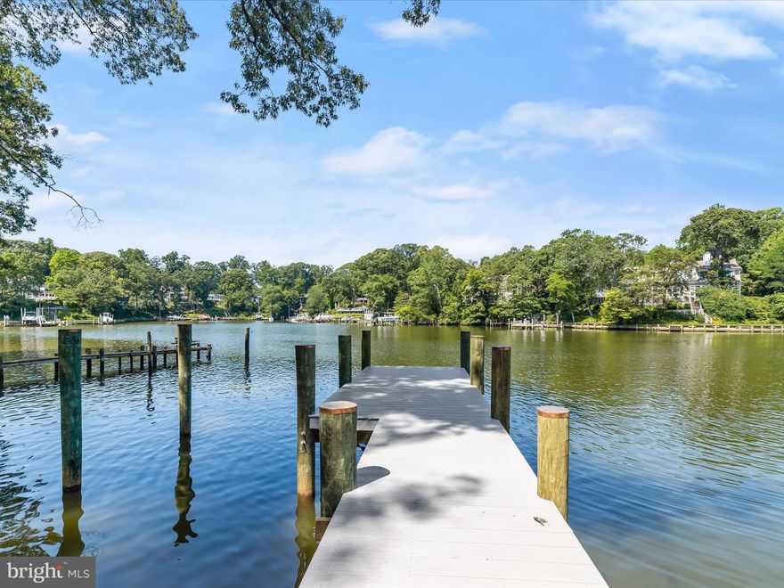 Perched along the serene shores of Mill Creek in the prestigious Magothy Shores community of Arnold, this one-of-a-kind newly built home redefines luxury waterfront living. Offering six bedrooms with four and a half bathrooms spread across three exquisite levels of impeccably designed spaces. This contemporary showpiece has a blend of elegance, innovative features, and breathtaking natural beauty, with two waterfront bedroom suites and versatile living spaces. As you arrive, a dramatic front makes a bold first impression, hinting at the sophistication within. Step through the front door and into an expansive open-concept layout, where floor-to-ceiling windows have views of the water and blur the lines between indoor and outdoor living. Soaring ceilings, an abundance of natural light, and extraordinary finishes, wide-plank flooring, porcelain and marble tile, and designer lighting elevate modern living with an inviting atmosphere. The show-stopping kitchen is nothing short of spectacular, equipped with high-end Thermador appliances and an eight-burner FORNO gas range with double ovens, along with a convenient pot-filler. Custom soft-close cabinetry with slide-out shelves, gorgeous countertops and backsplash, and a massive statement waterfall-edge island make this kitchen a chef’s dream. Relax and unwind in the spacious living room with folding glass doors that invite you to step onto the expansive deck, ideal for sunset dining, starlit gatherings, and daytime activities. Entertain guests in the two-story dining room that can accommodate any size gathering with a glass-enclosed wine room. Completing the main level is a dramatic half bathroom and access to the two-car garage. Ascend upstairs where a waterfront bedroom suite boasts a wet bar with a beverage fridge, walk-in closet and private balcony. The ensuite bathroom highlights a free-standing slipper tub, dual vanity, and a frameless walk-in shower with a rainfall shower head and jetted body sprayers. A loft on this level provides a versatile space as a sitting room, lounge space, office, playroom and more. Down the hall are two bedrooms with a shared bathroom complete with a walk-in shower, along with a convenient laundry closet for this level. Up the stairs, the top level has even more space for everyone. The waterfront primary bedroom suite is a retreat in itself, featuring a walk-in closet with motion-sensing lights, a wet bar with a beverage fridge that is perfect for morning coffee or evening drinks, and a balcony with stunning views. The spa-like ensuite bathroom is adorned with a jetted tub, dual vanity, and an opulent walk-in shower with a rainfall shower head and body sprayers. A large family room on this level adds more living space, with a kitchenette and balcony that make everyday living and entertaining a delight. Another two bedrooms and a shared full bathroom finish the top level, along with a second laundry closet for convenience. Enjoy the best of waterfront living in this remarkable new home, whether lounging or hosting parties, you will love spending time outside in the fenced backyard with beautiful views. Steps lead down to the water where a newly built pier provides access to Mill Creek, which leads to the Magothy River and the Chesapeake Bay. Every detail has been thoughtfully curated with dimmable and color-changing LED lighting, accent walls, zoned HVAC with Nest thermostats, two tankless water heaters, an electric vehicle charger in the two-car garage, and energy-efficient features throughout. This home offers a lifestyle that is both refined and relaxed. Just around the corner from everyday essentials, this location has an array of shopping, dining, and entertainment, plus waterfront amenities for enjoying life by the water. Explore nearby Annapolis and everything this wonderful area has to offer.  Some images have been virtually staged.