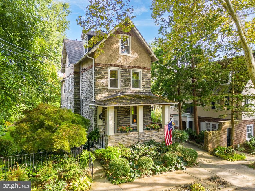Welcome to 114 W Abington Ave, a classic 5 bedroom, 2 and a half bath Chestnut Hill stone single with 1-car garage facing popular Pastorius Park, in a fantastic walkable location just 1.5 blocks from the Avenue. Lovely original details such as inlaid hardwood floors, deep windowsills and hand carved woodwork can be found throughout this charming home. Sit on the front porch, which is set up above street level, and listen to the Pastorius Park Summer Concert Series across the street, take a train into Center City for a play, or walk to the Avenue for shopping and dinner. Enter through the front door, with restored original leaded glass, to the dining room, with inlaid oak floors, crown molding and arched doorway to the living room. Sunlit from large windows, the living room features an additional entrance from the front porch, charming corner fireplace with marble and wood mantle, and nook with original built-ins, powder room and access to the basement. The living room leads to the renovated kitchen, which was expanded from the original footprint of the home with a tasteful and seamless addition. Featuring custom cabinetry, granite countertops, a large island with seating, 6-burner stove with custom copper and bronze Rangecraft range hood, custom mosaic backsplashes, and breakfast room with built-ins and gas fireplace, and side exit to the rear patio. The second floor of this well-appointed home features a landing with storage under the stairs, 3 spacious and sunlit bedrooms, each with ample closet space, and a renovated marble hall bath with walk-in shower. The third floor offers 2 large bedrooms, a cozy nook that would be perfect for a sewing or crafts room, and a hall bath with original clawfoot tub. The basement offers ample storage space, a powder room, and laundry area, and can be finished off for additional living space or an entertainment area. The outside spaces of this home are truly special, with a large slate patio in the rear of the home, surrounded by lush plantings and gardens, that leads to the level side yard via way of a charming wisteria arbor. Spend warm weather nights entertaining family and friends, or simply relaxing listening to local birds in Pastorius Park. A coveted 1-car garage rounds out this special property. The super convenient location is just 2.5 blocks from the St. Martins train station, for an easy commute into the city, a few blocks from the Cresheim Valley trails of Fairmount Park, and just 1.5 blocks from Germantown Avenue, which boasts a vibrant shopping and dining district. Don’t miss this opportunity to make such a unique home your own!