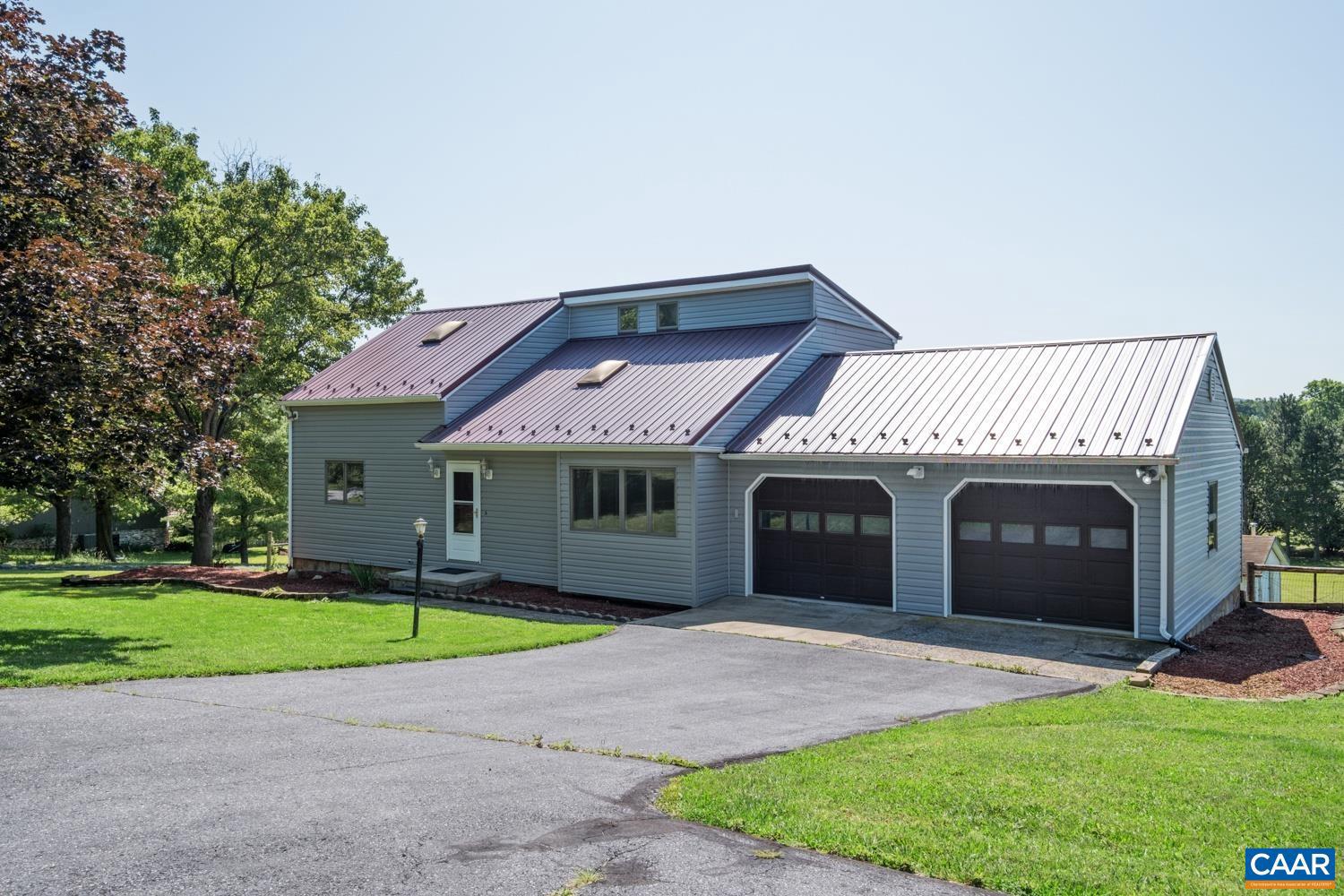 Newer metal roof, newer vinyl siding, new back deck, new kitchen backsplash, newly painted, and a spacious backyard with lovely views are ready for you! The main level features high ceilings in the living room, and an open floor plan in the main living space. A large deck is located off of the dining room, perfect for enjoying views and morning coffee. The backyard is large and fenced, and offers plenty of room for pets and play. The backyard also features a fish pond just by the covered patio. The primary bedroom is located on the main level. The second level features two bedrooms and a full bathroom, and one bedroom has new carpet. The finished basement extends the living space, and includes a third bathroom and a gas stove for additional warmth. This property is conveniently located close to Fishersville, Waynesboro, I-64, and Rte. 340 S.,Wood Cabinets,Fireplace in Basement