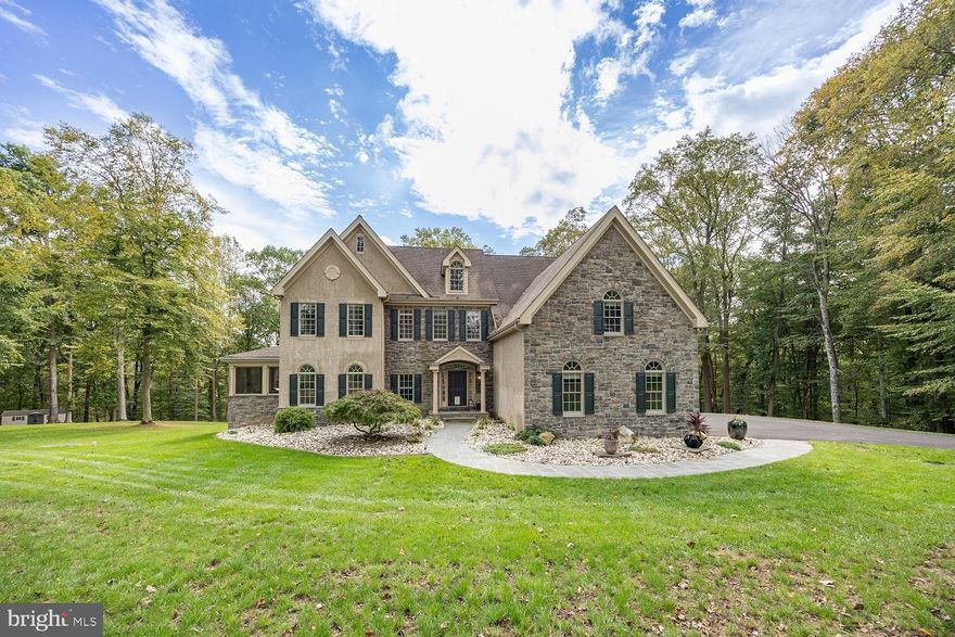 Magnificent Landenberg estate offering luxury, privacy, and true multi-generational living. Nestled among privacy-screen trees, this home features 5 BRs, 1 bonus room, 5.5 baths, and a 3-car garage with EV charger. The main level boasts Brazilian hardwood floors, a gourmet kitchen with Australian granite, and a two-story family room with floor-to-ceiling windows and automated shades. Upstairs, the primary suite includes dual walk-ins, a balcony, and a spa bath with enclosed steam shower. Two additional bedrooms each have their own full baths, plus an oversized laundry room with office space for convenience. The walkout lower level (9-ft ceilings) is ideal for in-laws or guests with 2 bedrooms, 2 full baths, office/gym, full kitchen, and separate laundry. Enjoy 1,400 sq. ft. of hardscaping, a heated saltwater swim spa with voice controls, putting green, private driving range and the White Clay Creek as a natural scenic barrier for unmatched privacy. Smart-home lighting, new blacktop driveway, all appliances, LED & OLED TV’s and furnishings seen in home during the tour are included.