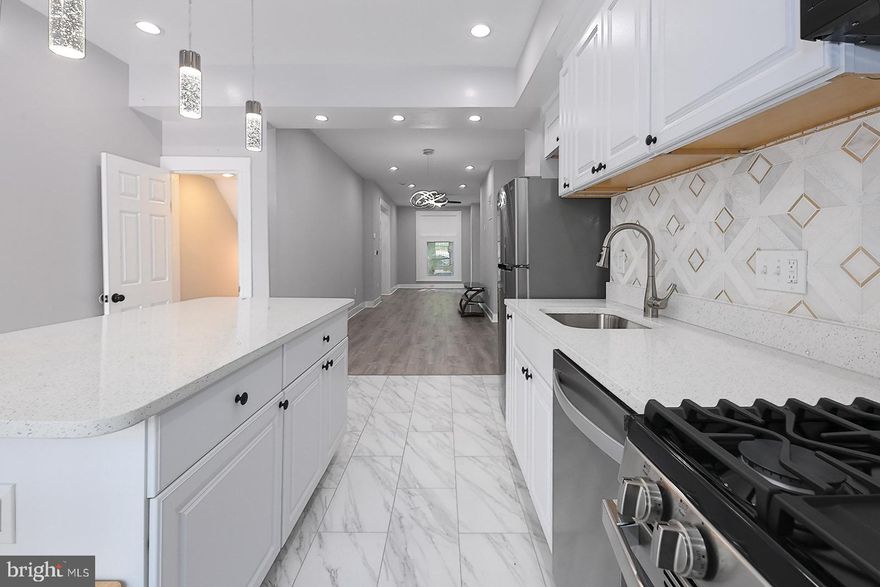 Beautifully renovated Federal-style Baltimore rowhome offering a true move-in ready experience in the McElderry Park neighborhood, just minutes from Johns Hopkins Bayview. Step inside to an open concept main level featuring a large kitchen island with knee bar seating, granite countertops, stainless steel appliances, above-range microwave, motion-activated faucet, and stylish tile floors. Luxury vinyl plank flooring flows throughout, complemented by modern finishes, ceiling fans in the bedrooms, and abundant natural light. The second level includes two bedrooms, a full bath with walk-in tiled shower, and a flexible middle room with closet that works perfectly as an office or bonus space. The fully finished basement adds even more living options with a bedroom, full bath, common area, and washer/dryer. Outside, enjoy a private rear patio, while the new roof and brand-new AC system provide peace of mind. Surrounded by neighborhood revitalization and convenient to parks, schools, and commuter routes, this home is an excellent choice for buyers and agents seeking style, function, and value within the city.Don’t miss your chance to own a fully renovated city home with modern finishes and timeless character—schedule your showing today and experience everything this property has to offer!