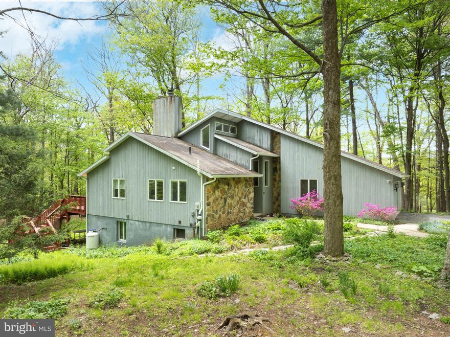 Wonderful private location yet close to town and PSU. Contemporary house situated on a 4-acre wooded lot. Open and sun-drenched with vaulted ceilings, skylights, and an abundance of windows. Main level primary bedroom with two-sided fireplace to living area. Opens to Sunroom, which is a beautiful place to read or socialize. Walk in closet and two compartment bath.

Living area is two story with a gas fireplace and wood floors. The sliding glass doors to the deck on this floor are all replaced recently.
Large kitchen eating area has newer appliances, wood floors, plant window and ample cabinets and counter space. Laundry area has two spacious closets.

Upper level has large open loft area plus two large bedrooms and an updated full bath. Storage off back bedroom.
Lower level is large open area with wet bar and wood stove. Full bath and bedroom plus a finished storage area.
Home has central air on main floor and wall units on second floor.
Large deck spans the back of the house. This is your chance to own a a piece of tranquility close to town yet set in a quiet rural area.

Home, Septic and Radon inspections in docs. Private road agreement. Upper Halfmoon Water.