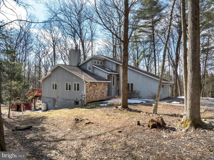 OPEN HOUSE - Sunday, March 8th, 11:00 AM - 12:30 PM.  Wonderful private location yet close to town and PSU. Contemporary house situated on a 4-acre wooded lot. Open and sun-drenched with vaulted ceilings, skylights, and an abundance of windows. Main level primary bedroom with two-sided fireplace to living area. Opens to Sunroom, which is a beautiful place to read or socialize. Walk in closet and two compartment bath.

Living area is two story with a gas fireplace and wood floors. The sliding glass doors to the deck on this floor are all replaced recently.
Large kitchen eating area has newer appliances, wood floors, plant window and ample cabinets and counter space. Laundry area has two spacious closets.

Upper level has large open loft area plus two large bedrooms and an updated full bath. Storage off back bedroom.
Lower level is large open area with wet bar and wood stove. Full bath and bedroom plus a finished storage area.
Home has central air on main floor and wall units on second floor.
Large deck spans the back of the house. This is your chance to own a a piece of tranquility close to town yet set in a quiet rural area.

Home, Septic and Radon inspections in docs. Private road agreement. Upper Halfmoon Water.