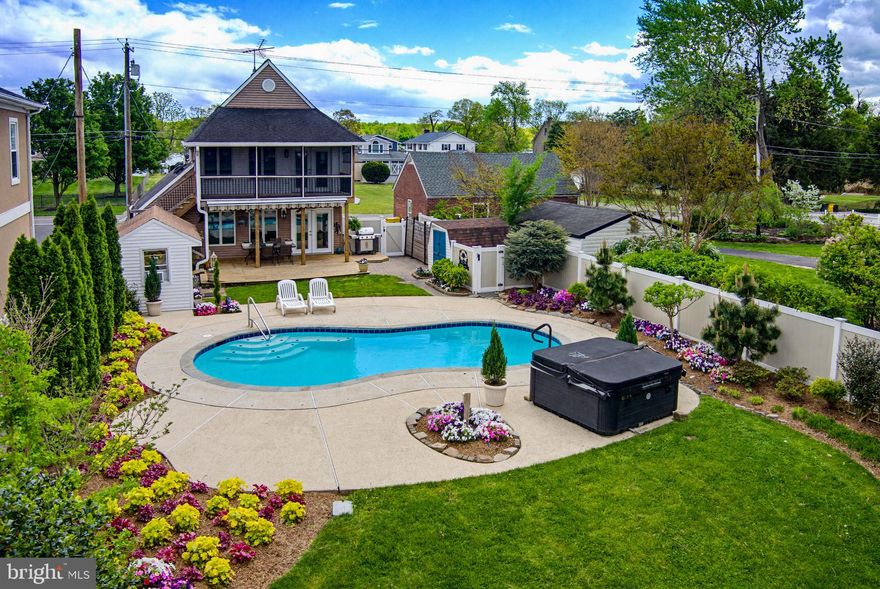 Absolutely stunning waterfront living with designer upgrades throughout.  Kitchen boasts granite, stainless steel appliances, over-sized island with seating, pendant lighting and lifeproof manufactured  Mountain Brook marble flooring.   All bathrooms newly renovated to include custom tile  and high-end fixtures and vanities.  Family room has crown molding.  Barn doors to main level bedroom. Primary bedroom has private, screened deck with vaulted tongue in groove wood-paneled ceiling and ceiling fan. Primary bath has dual vanities, spacious designer shower with waterfall showerhead, over-sized jetted soaking tub with ambient heat, and enormous walk-in closet.  Custom blinds throughout. Professionally designed landscaping, heated saltwater pool -- completely refinished and retiled with including LED lighting (2024), 8 person hot tub, and of course, the stunning and tranquil beauty of the new deep water pier with boat lift on the Back Creek of the Bodkin.  Sun-drenched backyard is perfect for entertaining. Main level  deck has awning, outdoor TV, and 2 ceiling fans.  New deep water 108' private pier with 10,000 lb boat lift,  2 jet ski lifts and electric power.  Private sandy beach with stone retaining wall.  Big Bodkin Creek water views!  Three storage sheds.  Front and back yard are professionally landscaped and continue to thrive with underground irrigation. HVAC - 2023; HWH - 2024; Well Pump - 2023; Well water filtration system and water softener - 2024.  2-500G Propane tanks -- one heats pool; 2nd directly connected to new Weber grill (conveys).  All TVs convey.  All outdoor planters convey. Furniture negotiable. Electric panel is wired for exterior generator hook-up.  Conveniently located near fine restaurants, shops, and golf courses.  Commuter routes to Annapolis, Baltimore and DC.  Vacation home or permanent residence -- your choice.  Sit on the look -out deck and enjoy the most glorious sunsets you've ever seen while communing with the numerous species of waterfowl, and accumulating crabs in your crab pots -- but be sure to keep an eye on that fishing rod -- just might be a big Rock fish on the line!