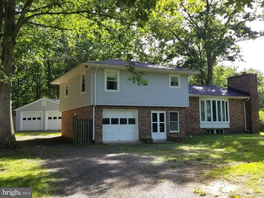 AWESOME LOCATION!  NO HOA!  This unique  home has undergone several updates in the past few months and awaits its new owners!  New siding, new roof, new HVAC, new bath, updated kitchen with stainless appliances and granite tops, living room and family room with fireplaces, dining room, 3 BR's on upper level with large bath.  Enjoy the stone patio out back with stone fireplace for entertaining.  Attached garage plus detached 24'x32' garage.  Nice trees surround home to keep it cool in the summer time!