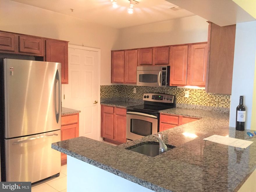 Beautiful ground floor unit with plenty of updates including hardwood floors in the living/dining area and granite counters in kitchen and baths. Largest floor plan in the community offers 2 bedrooms with den with bay windows, and 2 full baths and a balcony overlooking the courtyard/gazebo. 2 garage spaces+1 visitor pass. Front loading washer and dryer.