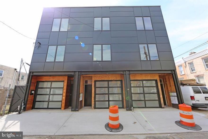 Brand New Construction in Fishtown with 2 Car Garage and large 45 foot Fiberglass Roof Deck  with Glass handrail to ensure max visibility of the view of the city skyline. and  a Pergola to provide some coverage from the sun so you can enjoy your deck in any weather.   The Garage door is a Frosted Glass  and  Aluminum and frosted glass garage door, insulated huge energy saver. The Garage has a Quality Garage door opener , WiFi ready, remote and sensor eye for safety when closing door.  There is also a  recessed in wall electric heater with thermostat to maintain temperature while staying cost efficient along with a  Storage area and mechanical room w utility sink in this Garage level.  The Rear yard area is fully paved concrete pad and fenced in for your privacy.  The High efficient HVAC condenser was strategically placed in yard for sound reduction while unit is active. This property is fully equipped with its own sprinkler system throughout , in addition to the hardwired  smoke and carbon monoxide detectors for safety.  Gas forced air heat GE electric water heater. With the homeowner in mind the house is equipped to support both gas and/or electric appliances. ( ie. range, water heater, dryer).  Recessed lighting and upgraded ceiling fans w remotes in each bedroom.  Master bedroom has  two huge closets, private master bath, heated tile floors his and her vanity, large walk in shower , thick frameless  glass shower door. The other 2 guest bedrooms are decent size, large windows letting in plenty of natural light and spacious closets.  The custom designed Kitchen has  plenty of cabinets and counter space. There is also  a solid white quartz top, huge island for meals and entertaining.   Beautiful  1/2  thick marble kitchen backsplash and stainless GE appliances: Gas range, Double door refrigerator, dishwasher, microwave, all are included and accent this gorgeous kitchen and eat in area.  The flooring is 8 in wide 8 ft long 3/4 inch thick solid red pine flooring you won't see anywhere else.  Heavy solid glass shower doors in all three bathrooms.   Matching Chrome Kohler modern faucets in every vanity . Front facade: black double wide pella casement windows, black aluminum composite panels, large structural steel columns which were set via crane on the first floor. The entry door is recessed to provide some covered space and the walls are lined with 1  thick natural cedar wood siding which has been conditioned, stained and sealed.