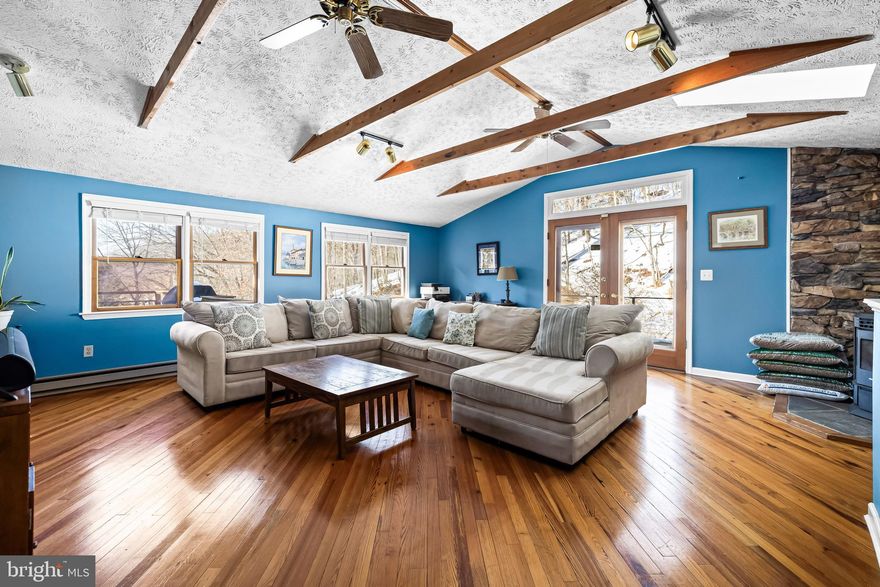 Come fall in love with this charming circa-1890 Parkton home set on 5+ scenic acres just moments from the NCR/Torrey Brown Rail Trail.  Multiple decks overlook Bentley Springs stream and beautiful natural surroundings.  The spacious eat-in kitchen features silestone countertops, a center island, gas cooktop and stainless steel appliances.  The inviting family room showcases vaulted ceilings with rustic beams and a cozy pellet stove.
The property includes a two-car attached garage, plus a one-car detached garage that formerly served as the mechanic shop at the New Freedom train station and was relocated to the property.  An additional outbuilding offers flexible space for storage, hobbies or a poultry house.  Recent improvements include a replaced BAT septic system, renovated bath w/heated flooring, blending historic charm with modern comfort.   Overhead drone photos show back property line in relation to BeeTree Run and NCR trail.  Bentley Springs NCR parking lot just down the road. Don't delay, take a look today!