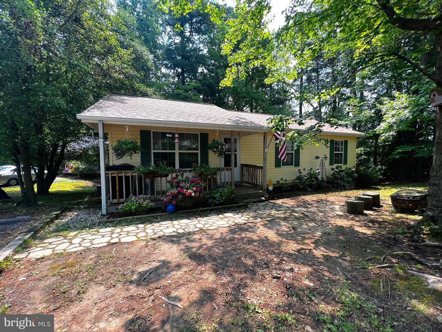 This is a corner lot just a few turns into the neighborhood. 3 Bedrooms and 2 bathrooms with a fenced in back yard. The privacy fence is great for containing little ones and fur family members!  Enjoy sitting on a covered front porch or take the party outback to the oversized deck. Inside you will find some updates already done, but plenty of room to add your own equity. Carpet has all been swapped out for laminate flooring and some fresh paint in a few rooms. The living room is large enough to hold a sectional and the kitchen offers a small pantry and room for a 6 person table.  There is a separate laundry room in the hall (so no washer and dryer in your kitchen!). The bedrooms are all decent sized with the primary being extra spacious and offering it’s own private bath.  Enjoy the peace of mind of also having a newer ROOF! 
The community lake and beach are just a few blocks away and if you are commuting to PAX this is a great location and boasts the sought after Calvert County School district.  The community offer a play ground, ball fields, camp ground, landing strip, community center and much more.  Make this your main home or a weekend get-a-way. Owners are in the process of packing so excuse any clutter.