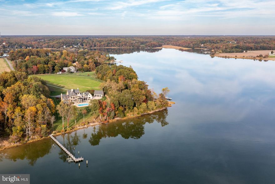 Stunning. Welcome to a world of unparalleled luxury and breathtaking beauty. Nestled along the tranquil waters off of the Potomac River, this custom-built four level waterfront estate on almost 18 acres, is a testament to architectural brilliance and sophisticated design. 
As you approach the grand entrance, you are greeted by a circular driveway, detached 3-car garage, attached 2-car garage, lush landscaping and a sense of serenity. Step inside and you'll be captivated by the focal point of the home, a striking spiral staircase that ascends to the four levels, adding a touch of drama and splendor. A private elevator also awaits to effortlessly transport you through each level of this palatial residence. The expansive living space is adorned with floor-to-ceiling windows, offering panoramic views of the shimmering waters that stretch beyond the horizon. The soul of this home is undoubtedly the gourmet kitchen, a culinary masterpiece featuring top-of-the-line appliances, custom cabinetry, a massive center island and a breakfast room with a groin vault ceiling that doubles as a gathering place for friends and family. Enjoy seamless indoor-outdoor living with access to an expansive terrace with retractable screens, perfect for al fresco dining or simply soaking in the astounding landscape. The flawless design of the main level seamlessly connects the formal living, dining, main living, full bathroom, butler’s pantry, study, half bathroom, additional office, laundry room, mudroom and kitchen areas, creating an atmosphere of effortless grandeur. One of the standout features of this estate is the luxurious study, a haven for those seeking a refined space for work or contemplation. The custom-built cabinetry, rich wood paneling, and expansive views create an atmosphere of insight and productivity. As you ascend the spiral staircase within it, you'll discover an additional upstairs library space and doors that connect to the primary suite that redefines luxury living. Wake up to wondrous views of the water, and unwind in the evenings in a recently renovated spa-like en-suite bathroom complete with a soaking tub and a walk-in steam shower that can reach 105 degrees. The primary suite also boasts a private terrace overlooking the pool, creating a serene sanctuary within your own home. The walk-in closet is a haven for the fashion connoisseur, providing two wings with ample space for two curated wardrobes. As you continue on the second level, discover additional well-appointed bedrooms, each with its own en-suite bathroom.  The fourth level offers a luxurious guest suite with its own bathroom fully handicapped accessible, a wet bar and a rooftop terrace commanding awe-inspiring views of the surrounding waters, creating an unrivaled setting for sunset cocktails or stargazing. The lower level is a crowning jewel, featuring a generous and versatile space that unveils a recreation area, guest or au pair suite, and a vast amount of storage.  The outdoor living space is a true oasis, featuring a sparkling saltwater pool that seems to merge seamlessly with the grounds and bay beyond. There is an inground timed sprinkler system providing a green and luscious lawn year round. The pier has been resurfaced and the mean low water is 8 feet, ensuring that priceless maritime adventures begin just steps from your doorstep. In the sought after Leonardtown school district, the property possesses a Silver Leed certification and can withstand a Category 3 hurricane with a reinforced roof. While you will feel miles away from it all, you will be enamored by the charm, history and convenience of the area. DC is 90 minutes away, St. Mary’s Airport is 20 minutes away and a five minute boat ride to the wharf and lovely downtown Leonardtown. The Breton Bay Country Club is just two miles away or visit nearby Solomons Island, the Patuxent Naval Air Station or enjoy a quick kayak ride to a nearby winery or a summer sea plane ride. Welcome home.