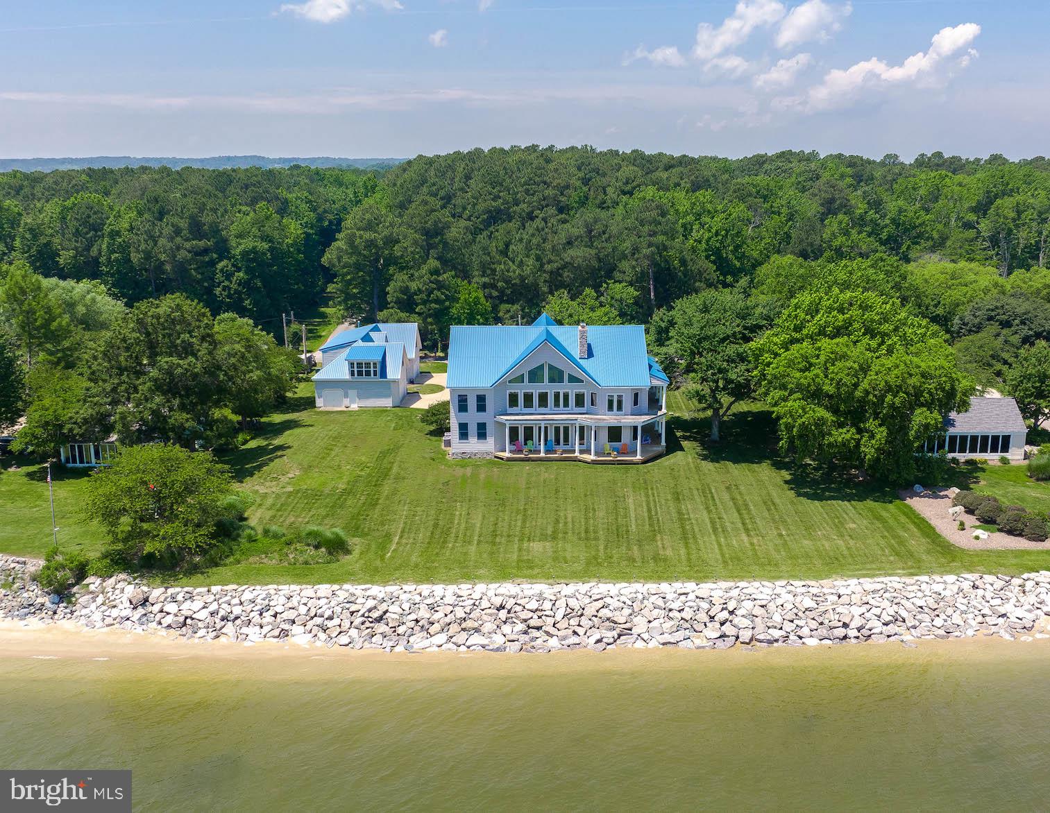 This is an extraordinary contemporary residence with wide open views of the Chesapeake Bay! This well maintained home features an open floor plan with floor to ceiling windows allowing this home to be flooded with sunshine and provide absolutely awesome views. The 1.29 acre lot is level and provides easy access to the sandy beach. The entire shoreline has stone revetment and the lot has been professionally landscaped.
Inside find a wide entry with curved staircase to the upper level. The main level features a great room with floor-to- ceiling stone fireplace (two-sided so you benefit on the dining room side) and doors leading to a covered porch on the Bay. Also find a dining area large enough to accommodate a crowd! Dining opens into the comfortable kitchen with a spacious pantry. The main level also hosts a bedroom, full bath and wonderful office with built-in cabinetry. On the upper lever, find a magnificent primary suite with stone fireplace, doors leading to upper deck area, and an enormous primary bath with huge shower, separate tub, and large walk-in closet. Oh, did I mention the views? Also find two secondary bedrooms with Jack-n-Jill full bath on the opposite side from the primary suite.
Outside find plenty of covered porch space to enjoy summer breezes and al fresco dining or entertaining. You'll also find a huge 4-bay detached garage for all the vehicles and toys, with an unfinished (completely floored/partially drywalled) second level that is large enough to proved a great deal of additional office/flex space. The rooves were replaced with metal which is great for a bay homes.
This is a gorgeous property with much to offer as a full or part-time residence. Thanks for visiting!