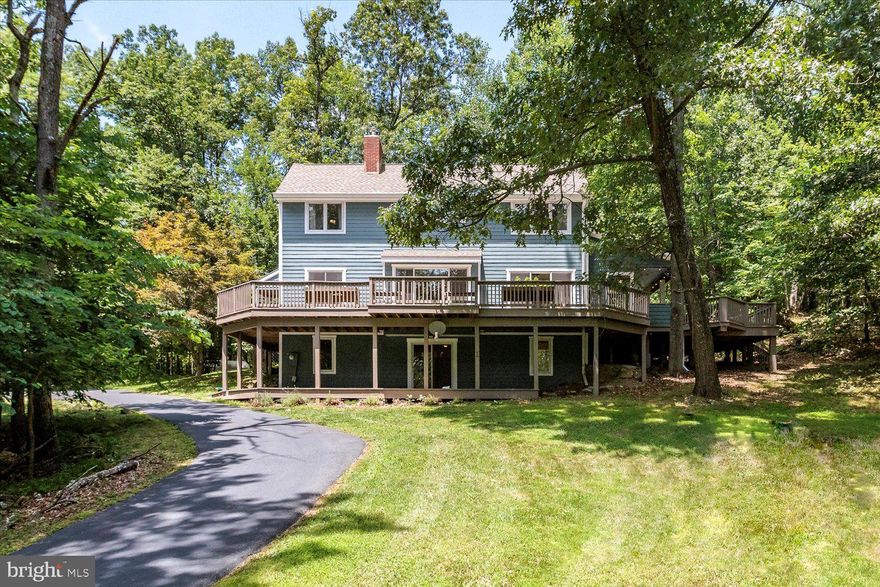 Tucked away on 10 private, wooded acres just minutes from Harpers Ferry, this one-of-a-kind 3-bedroom, 2.5-bath home offers an estimated 2,471 square feet of living space and a rare blend of seclusion, natural beauty, and thoughtful updates.
As soon as you arrive, you'll feel like you're on vacation. The property sits just off a paved road, with breathtaking views to the south and east. A welcoming foyer opens into the dramatic great room with soaring ceilings, a high-efficiency wood stove that heats two floors, and oversized picture windows that bring in the outdoors.
The kitchen is well-appointed with stainless steel appliances, an oversized pantry, and a sunny eat-in area that opens directly to the covered porch, perfect for dining outside in any weather. The expansive front deck stretches across the entire home and wraps around to join the porch, making it easy to relax, entertain, or simply take in the wildlife and star-filled skies.
Back inside, the main level offers a flexible bedroom ideal for guests or a home office, conveniently located next to a spacious powder room. Upstairs, you'll find two generously sized bedrooms and two full bathrooms, including a primary suite with vaulted ceilings and tranquil views of nothing but nature.
The walk-out lower level offers excellent light and space for a rec room, studio, or workshop. It leads to yet another deck and provides access to the surrounding outdoor space, which is fully private and peaceful. Additional features include luxury vinyl tile flooring and a large outbuilding, perfect for projects, storage, or even parking a boat.
Though you’ll feel a world away, you're just 20 minutes from the shops and restaurants of Purcellville and about 15 minutes from the MARC train to Washington, DC. Dulles Airport is under an hour away. Outdoor lovers will appreciate the proximity to the Appalachian Trail, Harpers Ferry National Historical Park, and miles of hiking along the Potomac and C&O Canal towpath. Plus, Loudoun County’s renowned wineries and breweries are all around you.
This is more than a home. It’s a lifestyle. Don’t miss your chance to own this private retreat.