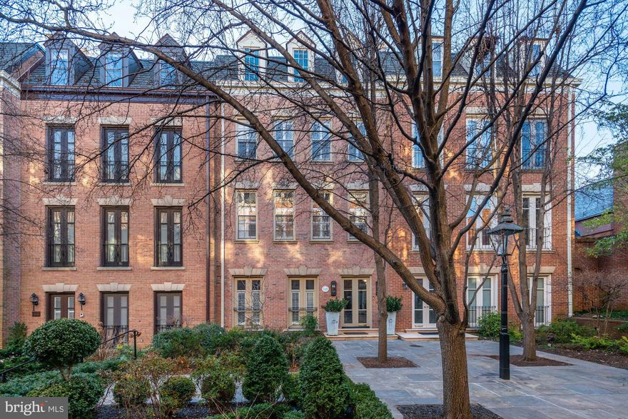 1820 Kalorama Square NW is distinguished in stature and impressive in presentation. Beautifully designed and tailored to fit the modern lifestyle, this five-level all-brick townhome in the gated community of Kalorama Square is steeped in impeccable finishes, hand-picked stone selections, and a floor plan made for large scale entertaining. With 5 Bedroom Suites and 5.5 Baths, this prominent residence spans approximately 4,500 finished square feet and is adorned with a number of comforts including an Elevator that services all 5 levels, an attached 2-Car Garage, a dedicated level for the vast Primary Suite, and an expansive private Patio. Through a well-manicured promenade and past the neighboring homes is 1820 Kalorama Square NW. The Main Level welcomes you with a wide and gracious Foyer with an elegant staircase that is lined with an imported wool sisal stair runner. The incredible Gourmet Kitchen is dressed in white quartz and features a Wolf steam oven, Wolf wall oven, Bosch dishwasher, Wolf 5-burner induction cooktop, pot filler, and a Sharp microwave drawer. Flanking either side of the Kitchen are both dining areas, including a charming Breakfast Room and a spacious Dining Room that opens to the rear Patio.   The Second Level is made up of the Living Room and Den, both warmed with beautiful fireplaces, custom millwork, and large windows. There is a lovely Wet Bar off the Living Room along with a Powder Room.   The Third Level is dedicated to the Primary Suite and lives comfortably with a Bedroom, two owner Baths, and a huge Dressing Room with a built-in wardrobe. The Dressing Room may be easily transformed into an additional Bedroom or an Office. There are two Bedroom Suites on the Upper Level, each with their own private Bath.   The Lower Level is a functional and well-designed space that boasts an Au Pair or Housekeeper's Suite, a Laundry Room, a Full Bath, and access to the 2-Car Garage. The Au Pair/Housekeeper's Suite is spacious and thoughtful, with a Bedroom and connecting Sitting Room.  Kalorama Square is located at the corner of Phelps Place NW and S Street NW in the esteemed neighborhood of Kalorama. This private and gated community consists of merely 25 townhomes and offers an autonomous enclave that is meticulously maintained and is accompanied by a number of desirable amenities. Residents enjoy the swimming pool, 24/7 security, landscaping and private 2-car garages. Sited on the former Holton-Arms School Gym and playing field, these townhomes were built in the mid-1970's and have been wonderfully cared for. In addition to the wonderful amenities of this special community, Kalorama Square is also adjacent to Mitchell Park and across the street to the Spanish Steps. Bounded by the Massachusetts Ave NW and Connecticut Ave NW corridors, there are a number of Embassies, restaurants, and cultural experiences that surround this lovely neighborhood..