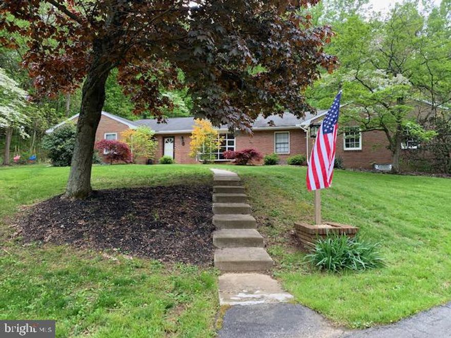 A beautiful gem in desirable Smithsburg, MD! This custom-built brick rancher sits on a 7+ acre wooded lot and has been recently renovated; move-in ready! Located just outside Smithsburg town limits, close to major commuting routes, with plenty of small-town conveniences such as grocery, hardware, local restaurants, entertainment, and fantastic schools. 
  As you enter the home through the front door, you're greeted by the entryway and large family room, with a wood burning fireplace and ample bay window overlooking the lush front yard.  Through the family room and you're in the dine-in kitchen.  With dazzling white quartz countertops, soft-close cabinetry, stainless steel appliances, an exposed brick wall, recessed lighting, and new wood flooring, the kitchen offers ample room to gather while preparing meals.  From the kitchen, down the hallway, you'll find two large bedrooms offering plenty of space to unpack.   A full bath with tub and tile flooring services both of these bedrooms.  Further down the hall, the primary bedroom is enormous and bright, with a walk-in closet and completely renovated en suite bath. Hardwood floors and ceramic tile throughout this home make upkeep easy.  A separate laundry room is located on the first floor within the oversized 2-car garage. A third garage is located underneath the home, accessible by the basement or the walk-out door.  The large block basement with poured concrete floor has been completely waterproofed and sealed, ready to solve your storage needs or be turned into living space.  There's also a detached workshop ready to be put to use.  Newer HVAC system and hot water heater will offer years of worry-free comfort. If you've been looking for one-level, low maintenance living with the privacy of the woods and convenience of the city, then have a look at this impressive property located at 11828 Wolfsville Road.
