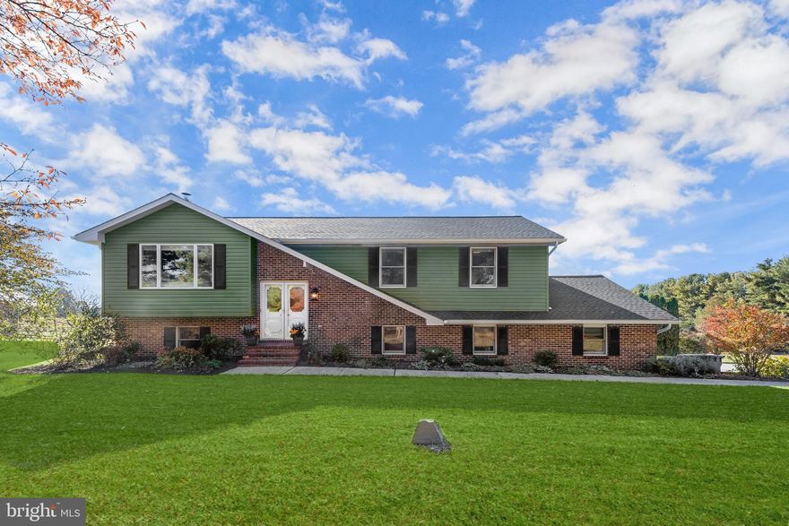 Nestled on three open acres with sweeping farmland views, this charming split-level home combines modern updates with rural tranquility. The property backs to picturesque farmland and offers endless possibilities for equestrian pursuits or homesteading. A versatile barn currently functions as a workshop, but could be converted back into stalls for horses or other animals. The home has been thoughtfully updated with a new roof, new vinyl siding with wrap, and a beautifully renovated kitchen. The brick and vinyl siding exterior is complemented by beautifully landscaped grounds that invite you into an open floor plan, perfect for entertaining and comfortable living. The spacious living room features a large picture window, a new electric fireplace with a charming faux reclaimed wood mantle, and gorgeous hardwood floors. The dining area flows seamlessly into the renovated kitchen, which features ceramic tile flooring, a decorative subway tile backsplash, 36” soft-close shaker-style cabinetry, stainless steel appliances, and quartz countertops. Step through the dining area to the expansive deck and take in the stunning views of the surrounding landscape. The primary suite offers a peaceful retreat, featuring private deck access, a neutral color palette, a walk-in closet, and a luxurious en-suite bath. The bath showcases a subway-tiled walk-in shower with honed wall tile and pebble flooring. Two additional bedrooms and a well-appointed hall bath complete the main level.  The fully finished lower level features a warm and inviting family room, complete with luxury vinyl flooring, a wood-burning stove, and access to the patio and a relaxing hot tub. A fourth bedroom, powder room, and convenient two-car garage access complete the home. Conveniently located along Route 23 near MD-152 and MD-146, this property offers the perfect blend of modern comfort, rural charm, and easy access to nearby amenities.