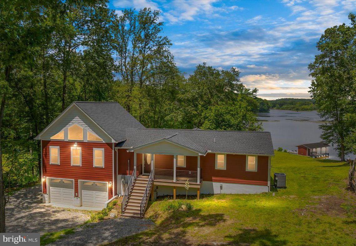 A rare opportunity to own a beautiful waterfront home at an exceptional price! Discover the beauty and serenity of this fully renovated waterfront retreat on the public side of Lake Anna, Virginia. You'll experience peaceful lake living and the most gorgeous sunsets from this property! Located on a quiet cul-de-sac and within walking distance to the community common area docks, boat ramp and playground. Featuring 3 bedrooms, 3 full baths, 2,218 finished square feet (plus 456 unfinished square feet), this thoughtfully designed retreat is move-in ready with top-of-the-line upgrades throughout. Step inside to a bright and inviting family room featuring soaring vaulted ceilings and a striking wall of glass windows that overlook the lake. The open-concept floor plan seamlessly connects to the gourmet kitchen, complete with sleek quartz countertops, stainless steel LG appliances, double wall oven, a massive center island with pendent lights above and a walk-through pantry with barn doors. Every detail in this home has been carefully considered and renovated, with luxury vinyl plank flooring, soft-close cabinets and drawers, built-in soap dispensers, and self-cleaning bidet toilets with heated seats, warm water, and a dryer feature. Additional premium touches include Ascend composite insulated cladding siding with a lifetime transferrable warranty, new roof, all new plumbing, electrical, insulation, HVAC, pressure tank, whole house water filtration system, a whole-house attic fan, refrigerator with an ice maker that produces large round ice cubes, rainfall shower heads with handheld wands, and custom tile showers with glass doors. The main level lakeside primary ensuite showcases double barn doors, a walk-in tile shower with glass door, double vanity, a spacious walk-in closet and has direct access to the back deck. A second lakeside bedroom with deck access, a full bath and laundry room complete the main level. The walkout lower level features another lakeside ensuite with a private full bath, a mudroom and an unfinished storage/utility room. The fully finished 2-car garage (710 sq. ft.) is heated and cooled with a mini-split wall unit and features a third lakeside garage door, perfect for drive-through boat storage. All three garage doors are insulated for year-round comfort. Step outside and enjoy seamless indoor-outdoor living with a partially covered composite deck and a spacious concrete patio—ideal for cookouts and family gatherings. The 7-person hot tub, purchased in 2024, conveys with the home! Down by the water, you'll find your own concrete boat ramp, a covered boathouse with an electric boat lift, storage room, floating sun deck and three jet ski pads—perfect for kayaking, canoeing, fishing, paddle boarding and endless lake adventures Approximately 125 feet of shoreline. Two sheds and a carport also convey. Great location; just minutes by boat or car to local dining, MooThru ice cream, Below Deck LKA for deli sandwiches and pizza, an arcade, and mini golf. Plus, it’s less than two hours from D.C.—making it an ideal weekend getaway or full-time residence. Your dream lakefront escape is waiting—don’t miss out on this incredible opportunity! Fiber Firefly internet expected spring 2025. Short term rentals are allowed! Priced under appraised value. See appraisal in MLS documents section!