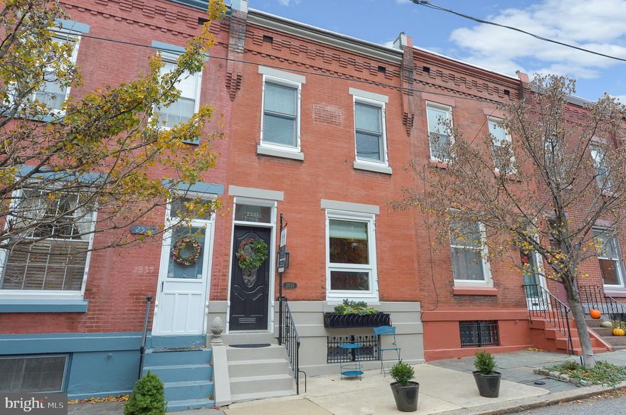 "Pretty as a picture" sums up this prime location Art Museum rowhome, tucked behind The Perelman Building on one of the friendliest streets in Fairmount.  Edison lights strung the length of the street twinkle at night & block parties are scheduled throughout the year.  2 bedrooms, 1.5 bathrooms with second-floor laundry and private backyard.  A tasteful blend of old and new: original pumpkin pine floors, but energy efficient Anderson windows, central A/C, recessed lighting, and every room wired with built-in speakers.  Enter from the marble-floored vestibule into the open living/dining space with built-in bookcases and exposed brick.  Large sunny window with remote control custom silk Roman Shade.  Powder room added in 2018 but blends in like it has always been there. Updated kitchen with matching black stainless KitchenAid appliances, granite countertops, extended height maple cabinets and custom Roman shades of hand-blocked fabric from Edinburgh, Scotland.  Walk  out to your private patio, behind which is a handsome stone wall with an arched opening.  All of the houses on the block were built with three bedrooms upstairs and one tiny bath; a previous owner reconfigured the second floor, to create two large bedrooms, a walk-in closet, and a spa-worthy bathroom with honed marble vanity and laundry closet.  The basement walls have been completely parged and painted, adding ample space for workouts, crafts, and storage.  Easy walk to Boathouse Row, Whole Foods, Target, and The Barnes.