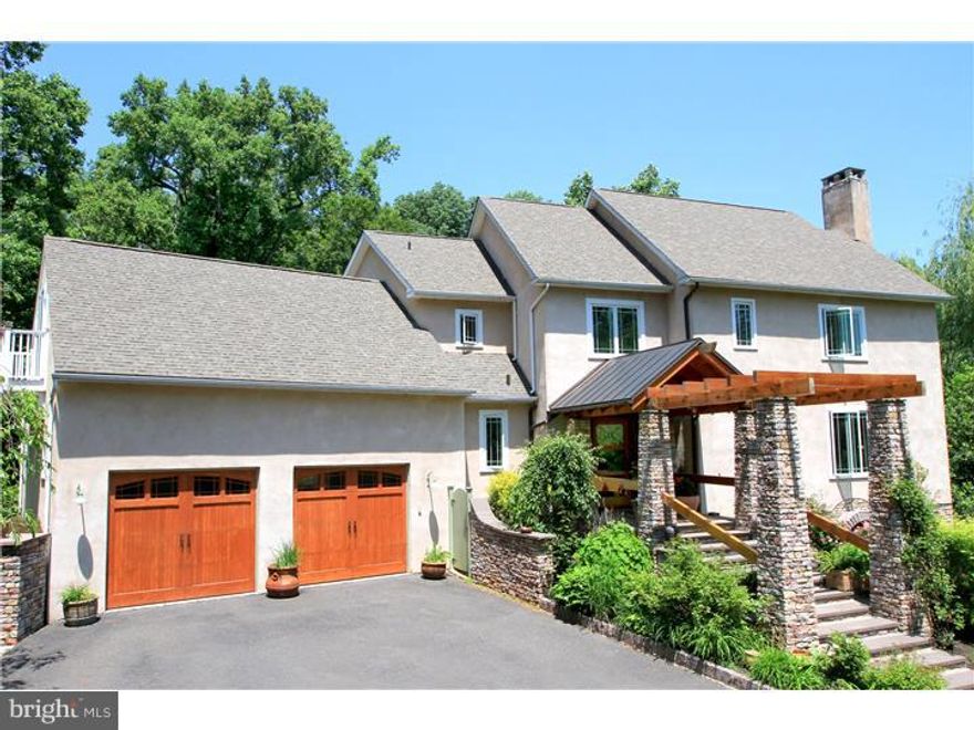 An eclectic mix of East and West coast styles come together in this prime Solebury location high up on the hill above historic Center Bridge. Expressive tile work adorns the home throughout, including floor to ceiling glass tile walls in the kitchen and bathroom, handmade Spanish-style tiled floors with hand painted accents, unique fixtures and finishes throughout combine California craftsman with New England cottage. The four bedroom home enjoys mostly 9+ foot ceilings and a wide open floor plan, moving effortlessly between the kitchen, dining and living room. A dramatic atrium connects two main living areas, which offers the opportunity for an in-law suite, guest quarters, expansive home office, or a first floor master suite. The master suite boasts an 11' vaulted ceiling, oversized walk in closet, and en suite full bath. The secondary bedrooms share a common full bath with separate wash rooms and pass through to a large bonus room with balcony. Inside and outside flow effortlessly, through many Anderson French doors, onto the pergola-shaded back terrace or front wrap around veranda. Through the bright atrium is the fourth bedroom on the main level, with en suite full bath and a large sitting/reading room, this bedroom could make a great in-law or guest quarters. Above sits a large office or bonus room. The finished lower level walks out to grade, has a fireplace, TV/media area, workout area, and a full bath. A charming springhouse-style outbuilding offers a whimsical get-away space for relaxing. Finely landscaped, accented with outdoor lighting, and a convenient circular driveway off the oversized garage. This home is offered for the first time and not to be missed!