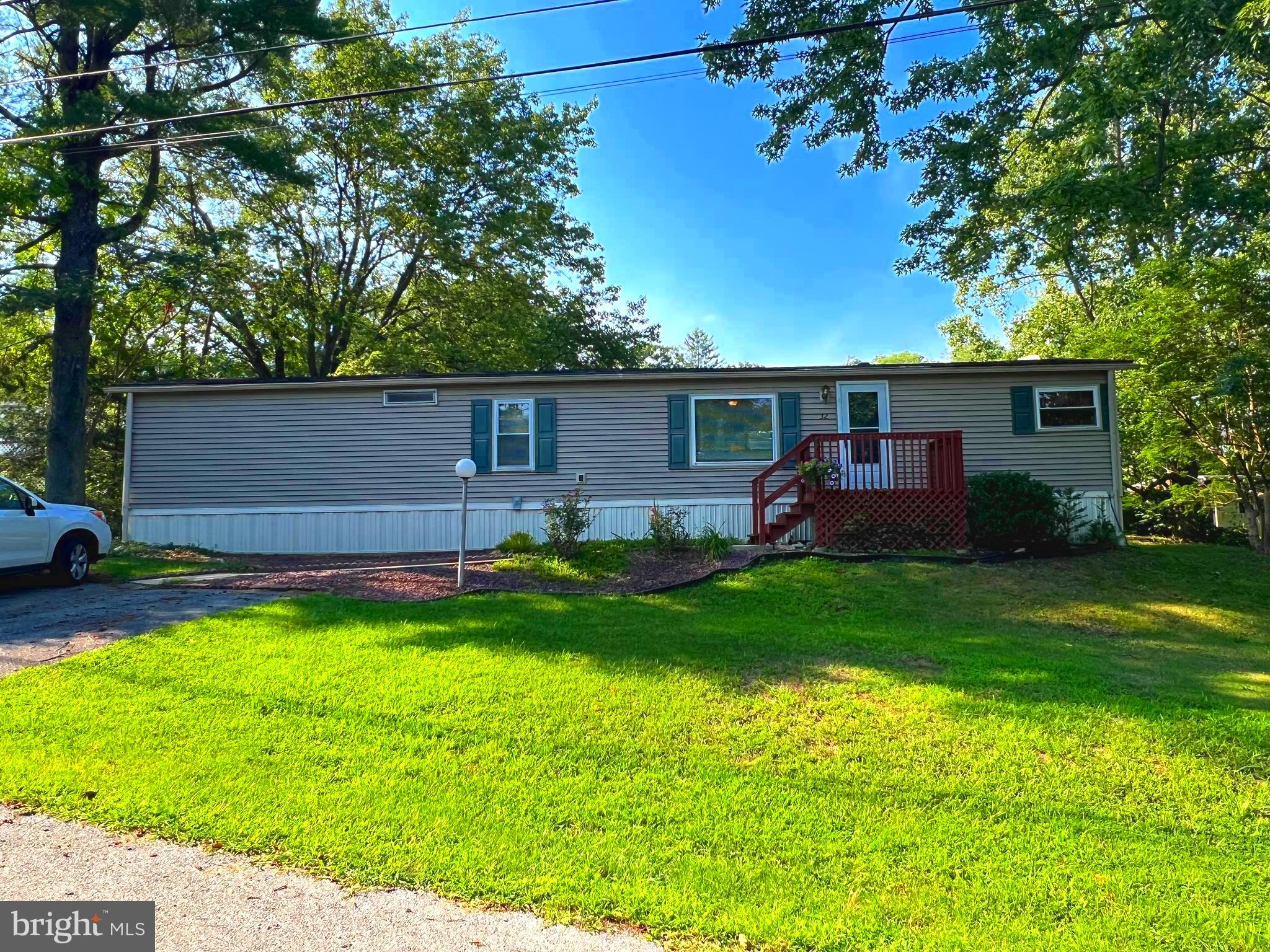 This 2 bedroom 1 bath home is located in a quiet community near Downingtown. The front of the home faces woodland which provides for a secluded front lawn and outside area. The home features an open layout and a modern bright color scape lending to a light and airy feel. The kitchen includes a 4-burner gas range, refrigerator and dishwasher. The combination kitchen/living room provides a spacious environment with plenty of natural light. The living room features a ceiling fan and carpeted area, and a sliding glass door leading to an 8x10 deck. This home is serviced by a newer central A/C system, propane heat and community sewer and water. Lot rent is $565/month which includes water, sewer, and snow removal. Pets are allowed per landlord's permission at an additional fee of $10/month. Owner has taken excellent care of maintaining this home which is only minutes away from Downingtown, and only about a half hour from West Chester with all the shops, malls, restaurants and amenities they provide.