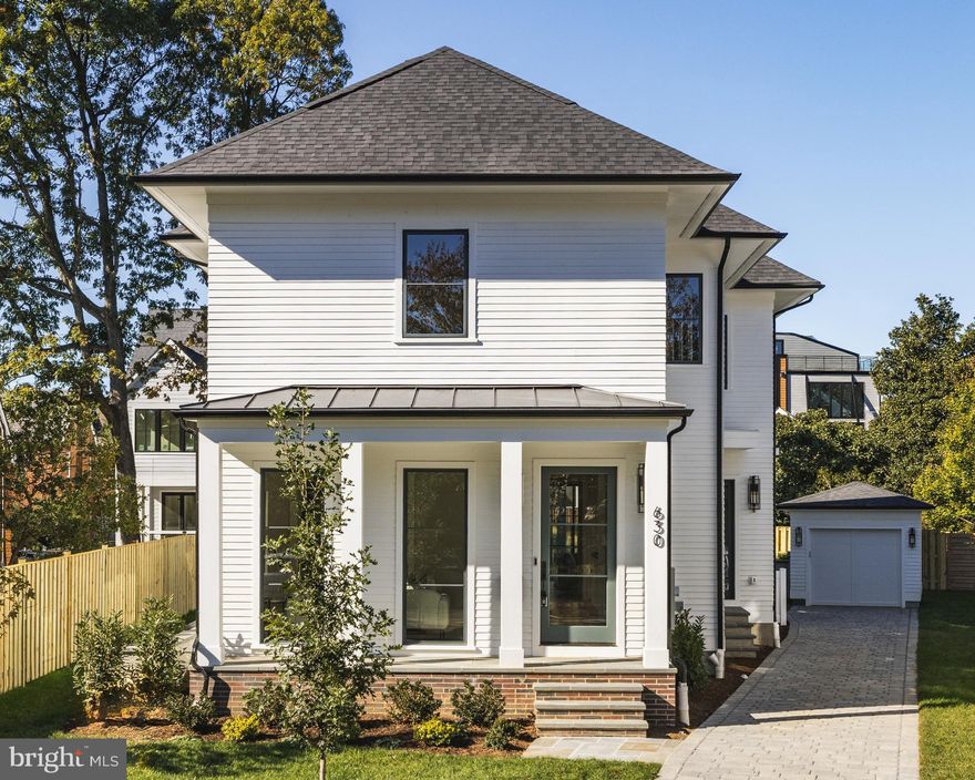 Tucked within the tree-lined streets of Ashton Heights and just moments from both downtown Clarendon and Ballston, 630 North Kenmore Street balances modern design with timeless elegance in one of Arlington’s most desirable neighborhoods. Developed by the Ventura Group, designed by GTM Architects, and with interiors by Kelly Knebel Designs, the home has been newly imagined from the ground up by an illustrious team of artisans.
 
The understated façade makes a subtle first impression, with white brick and Hardie Plank siding providing contrast against dark aluminum Marvin doors and windows. A deep paver driveway to the side is minimally intrusive and leads to a private detached garage at the rear of the property. The front entrance, tucked along a welcoming flagstone porch, opens into a dedicated reception area with a light-filled den positioned to one side.
An ethereal ambiance is enhanced by ten-foot ceilings and eight-foot doors on the main level, along with white oak hardwood flooring and substantial Emtek hardware throughout. Striking Visual Comfort and Hudson Valley light fixtures complement sleek WAC recessed lighting, adding visual interest and highlighting the clean architectural lines.
 
At the center of the main level is a grand stair hall, showcasing a sculptural white oak staircase with custom railings. Opposite the stair hall, the formal dining room is framed by a dramatic wall of glass and is thoughtfully scaled for elaborate entertaining. A butler’s pantry with wine fridge offers a seamless connection to the kitchen. A vestibule with powder and mud rooms bridges the transition between the formal and informal spaces.
 
The informal living areas span more than 30 feet in width, offering true open-concept flow. The family room features a gas fireplace and opens directly onto a covered rear flagstone screened-in porch, creating an ideal indoor-outdoor connection. Adjacent to the family room, the chef’s kitchen is a striking union of design and function. It features fully custom Alpine cabinetry, quartz countertops, and a full suite of Sub-Zero, Wolf, and Cove appliances. The adjoining breakfast area is bathed in natural light from three walls of glass.
 
Upstairs, the primary suite is a private retreat overlooking the rear lawn. Dual walk-in closets include extensive custom built-ins, and the spa-inspired bath offers radiant heated flooring, a curbless shower, a soaking tub, a double vanity, and a private water closet. Three additional bedrooms are well proportioned and feature private ensuite baths. A dedicated laundry room with full-size Electrolux appliances completes the upper level.
 
The lower level mirrors the scale of the main floor. A recreation area spans more than 30 feet in width and is anchored by a built-in bar with a wine fridge. A fifth bedroom with a walk-in closet and full bath, along with a fitness room, complete the space.
 
Technologically advanced and thoughtfully designed for the future, the home is pre-wired to accommodate a comprehensive smart home suite. Integrated features include ceiling-mounted surround sound speakers, wireless signal boosters on every level, and a robust video surveillance system.
 
The rear lawn unfolds as an immaculate green canvas, perfectly proportioned and thoughtfully irrigated, offering a refined backdrop for elegant outdoor living and entertaining.
 
Positioned just steps from the Orange Line Metro and minutes from Washington, DC, 630 North Kenmore Street blends exceptional craftsmanship, forward-thinking design, and a premier location. It is an inspiring example of modern urban living at its finest.