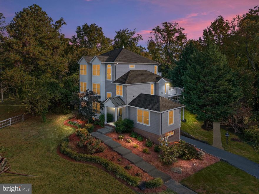 Welcome to 5108 Mountain Road, a breathtaking craftsman estate set on 2.5 acres of natural beauty and privacy in the heart of Pasadena. Originally built in 2002 and completely reimagined in 2025, this home combines timeless architecture with modern luxury and meticulous attention to detail. The setting is extraordinary — approximately three-quarters of an acre have been beautifully cleared and landscaped, creating a picturesque open yard perfect for garden parties, family gatherings, or evenings around a fire pit under the stars, while the remaining land is preserved in protected forest conservation, ensuring privacy, serenity, and an ever-changing backdrop of natural beauty. The property overlooks a peaceful horse farm and enjoys tranquil seasonal water views that glisten softly through the trees — close enough to feel the calm of the Magothy River, yet perfectly secluded from the world.  Inside, the home spans three levels of refined living, filled with natural light, craftsmanship, and architectural elegance. The main level was designed for connection and entertaining, featuring gleaming hardwood floors, coffered ceilings, dramatic trim work, and exquisite millwork throughout. The chef’s kitchen is a showpiece, offering 42-inch custom cabinetry, a built-in range, professional-grade stainless steel appliances, hand-selected tile, the finest quartz countertops, and a sunny breakfast nook that’s perfect for casual dining or morning coffee. A grand dining room sets the stage for holidays and celebrations, while the living room — anchored by a fireplace and opening to a composite deck — provides an inviting space for gatherings both large and small. Two ensuite bedrooms and a stylish half bath complete this level, offering flexibility and comfort for guests or family.  The upper level is entirely devoted to the primary suite, a private retreat of rare scale and luxury. This peaceful haven includes a spa-inspired bath, expansive walk-in closet, cozy fireplace, sitting area, and a private office or gym that can also serve as a nursery. Step onto the balcony to savor quiet mornings or unwind at sunset as light filters softly through the trees.  The sunlit lower level features a two-car garage, additional bedroom, full bath, and a spacious den or media room — perfect for guests, hobbies, or a home fitness studio. Every inch of the home is spotless and beautifully maintained, enhanced by recessed lighting, ceiling fans, and custom finishes that showcase its craftsmanship and quality.  Outdoor living is where this home truly shines. The paver patio and built-in grill create an entertainer’s dream setting, while the expansive lawn invites outdoor games, summer cookouts, or simply relaxing in the peaceful surroundings. The brick and Hardiplank exterior, composite decking, and mature landscaping reflect timeless beauty and low-maintenance durability, and the long private driveway easily accommodates up to ten cars.  Adding even more flexibility is the detached guest cottage, featuring a full kitchen, bedroom, living area, private bath, and washer/dryer — ideal for multi-generational living, a college student, an au pair, or guest quarters.  Perfectly positioned just minutes from Downs Park, where more than five miles of scenic trails, a fishing pier, playgrounds, and panoramic views of the Chesapeake Bay await, this home offers a lifestyle that balances natural tranquility with everyday convenience. Nestled just a few hundred feet from Gibson Island on a quiet, friendly stretch of Mountain Road, and located within the highly coveted Chesapeake School feeder system, 5108 Mountain Road delivers a rare blend of elegance, warmth, and versatility. Every inch has been curated for comfort, beauty, and joy. This is more than a home — it’s a sanctuary, a gathering place, and a reflection of the life you’ve worked hard to create.