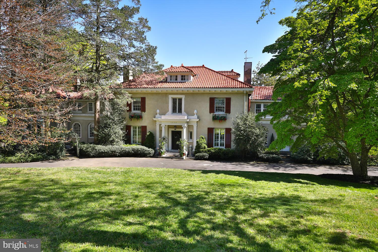 Stunning Greek Revival Colonial, sited on almost two acres in the best neighborhood in Rydal. Situated on a multi-terraced landscape with extraordinary mature trees and beautiful gardens, the house features seven rooms on the first floor for people to live a luxurious and civilized life. From the circular drive, step into the formal entry that runs front to back and leads, by French doors, to an expansive outdoor terrace, overlooking a fountain and pool. To the right of the foyer is the formal living room, with French doors, and fireplace. The welcoming sunroom, with fireplace and windows on three sides, is reached from the living room. The formal dining room with fireplace and floor-to-ceiling bay window sits to the left of the foyer. Beyond the dining room is the spacious kitchen with high-end appliances and beautiful arched windows. Beyond the kitchen is the casual family room which leads to a covered porch and to the garage-end of the driveway. Completing the first floor are two powder rooms (one at the front door and one off the family room), an office/den at the front of the house, an ample coat closet, and the start of the stunning turned staircase to the second floor. On the second floor, you will find a beautiful primary suite with an outfitted dressing room and a large bath with whirlpool tub and separate shower. There are four more bedrooms and three more bathrooms on the second floor, all are spacious and bright. There is also a screening room for movies and video games, and a laundry area conveniently located near the bedrooms. A door in the second floor landing leads to the third floor space that could serve a multitude of uses, from guest room, to office, to exercise space, or studio. Across the driveway from the first floor family room and covered porch is a four-car garage with attached living space .