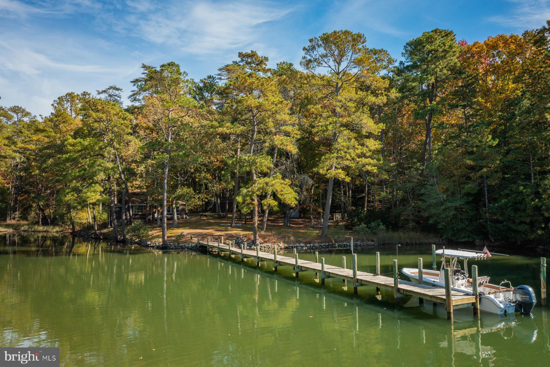 River cabin with 2 bedrooms, 2 full baths, eat-in kitchen and bonus living space on second floor. This property is comprised of 2 waterfront lots, to include a .86 acre buildable lot. Together, these lots offer great views of Myer Creek, 2.46 acres of privacy, 236’ waterfrontage, 3 to 4’ MLW and no HOA. Within walking distance of Yankee Point Marina, this waterfront retreat is the perfect place to get away. Great for private use or as an STR, the home has just the right amount of space to enjoy year-round. The outdoor deck is perfect for soaking up the sun and the propane fireplace is just right for the colder months. This property includes multiple outbuildings for storage and can convey furnished.
