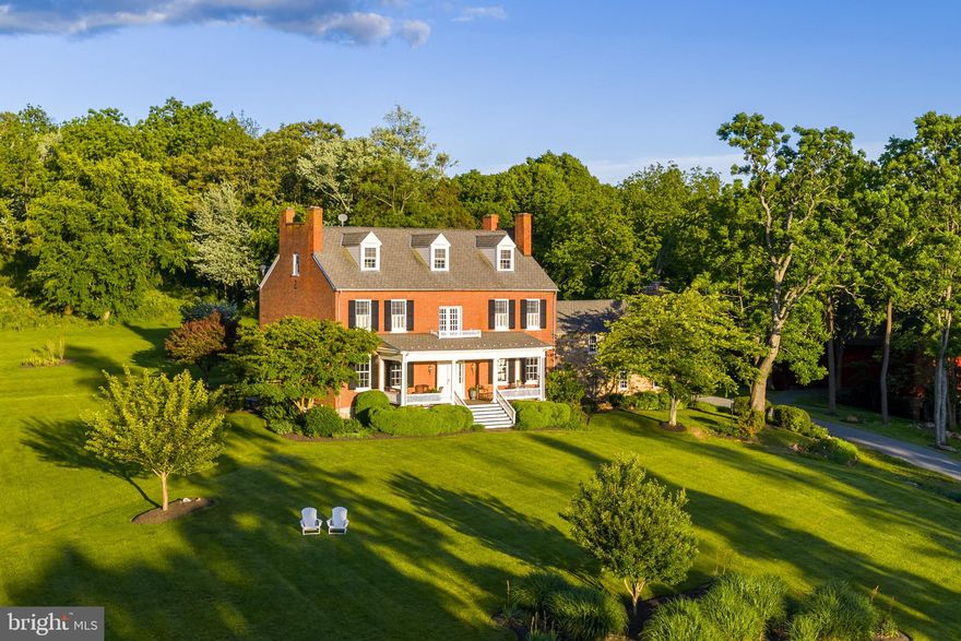Welcome to Melrose Farm – a rare opportunity to own an exquisite manor home just north of Historic Waterford. Built in 1856 and thoughtfully restored in the 1990s, this stately residence preserves its historic charm while incorporating modern updates, offering a perfect balance of classic character and contemporary comfort. Set on a breathtaking 50-acre lot, the property offers unobstructed panoramic views of the Shenandoah Mountains across the scenic Catoctin Valley.

As you enter, you are welcomed by beautifully refinished original hardwood floors, doors, windows, and millwork—preserving the home’s historic charm while offering renewed elegance and functionality. Soaring ten-foot ceilings add to the spacious feel and classic appeal of this stately brick Colonial, which proudly showcases its original architectural details, including 10 fireplaces, a three-story staircase, and three inviting porches. The grand living room, complete with two gas fireplaces, provides a warm and inviting setting for gatherings, while the formal dining room—anchored by a stunning fireplace—offers the perfect backdrop for special occasions and entertaining.

Timeless craftsmanship is evident throughout, with custom trim, exposed beams, intricate woodwork, and all-new designer light fixtures. The gourmet kitchen, renovated in 2018, features custom cabinetry, quartz countertops, a Sub-Zero refrigerator, and Wolf appliances—designed for both beauty and function.

The second floor features three spacious bedrooms, including the primary suite with a spa-like renovated en-suite bath. The fully finished third floor adds two additional bedrooms and a full bath—ideal for guests, a home office, or creative pursuits. The original stone wing offers a versatile space with a private home office featuring a wood burning stove, and an additional living room and bedroom—perfect for an in-law suite or extended stay guests.

Just off the kitchen, a sun-drenched sunroom provides a quiet retreat for morning coffee or an afternoon read. The stone patio surrounded by thoughtful hardscaping is ideal for entertaining, while the recently restored front porch offers the perfect spot to enjoy evening sunsets. A large bank barn with full 100-amp electric service offers additional entertaining space and endless potential. Option to purchase all furniture and farm equipment under separate agreement.

Located within the desirable Woodgrove High School pyramid and just minutes to renowned wineries, breweries, shopping, dining, and only 35 minutes to Dulles Airport—Melrose Farm is a private retreat with convenience close at hand.

Enjoy, and welcome home.