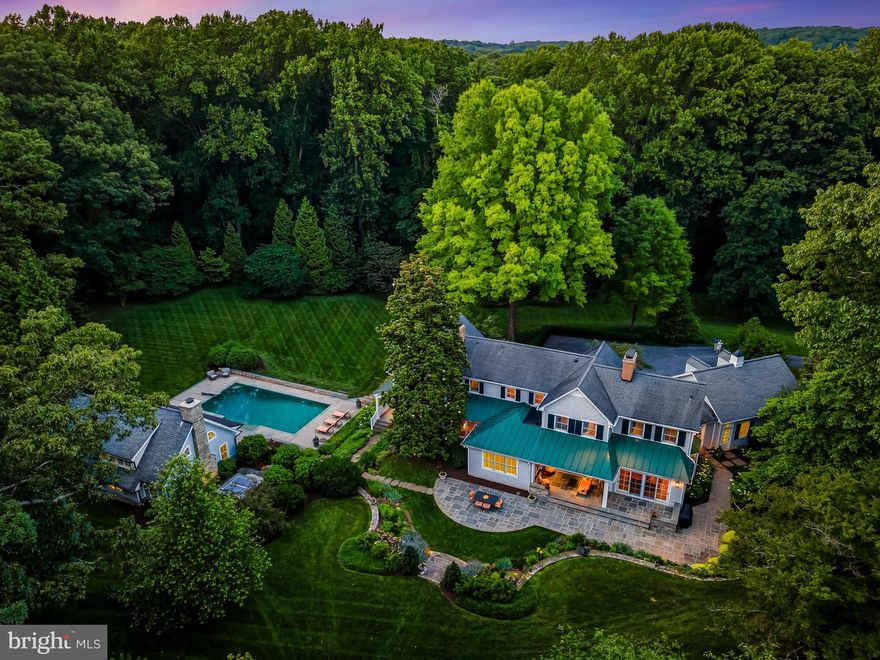 Trust your instincts. Experience unfettered livability and complete privacy on this estate property situated upon 3.5+ acres within a vibrant Greenspring Valley neighborhood. Pass through the neighboring golf course and enter the long private drive to find this remarkably stylish, totally renovated and expanded colonial together with the extraordinary pool house beckoning you to escape to personal retreat and opportunity for grand celebration. Step back in time 45 years to witness the relocation of the Circa 1900s farmhouse, then fast forward 25 years to envision a new family begin a series of masterful renovation and expansion projects, now realized. The residence features meticulously crafted architectural elements, millwork, fine finishes, high-end systems, five fireplaces, and a harmonious unity of traditional elegance and contemporary design. Entertain with ease in the stunning formal living and dining rooms, and casual spaces filled with natural light. Oversized doors open to the surrounding gardens, covered porches, and bluestone terrace with sitting walls for seamless flow between indoor and outdoor spaces. The spacious family room with brick herringbone floor, woodburning fireplace and entertainment center opens to the deluxe chef’s kitchen anchored by a large island with breakfast bar and features premium wide plank oak flooring, honed marble counters, pantry, a gas fireplace for seasonal enjoyment, and space for informal dining. Deluxe stainless appliances include a 6-burner gas cooktop, double wall ovens, and warming drawer. Nearby, a mudroom with cubbies and closets serves as a butler’s pantry with second refrigerator, laundry hook-up, and convenient dog wash. A main level bedroom suite offers private getaway for guests and is adjacent to a charming study opening to a covered porch facing the heated pool, providing the ultimate remote workspace. Ascend to the gracious primary suite which includes two large walk-in closets and a luxurious white marble bath with soaking tub and steam shower. A gallery hallway leads to three additional bedrooms, two full baths, and laundry. The finished walkout basement provides generous storage and space for play or second home office. Designed by Peter Ratcliffe and constructed by John Tiralla, the 1000 sq. ft. hallmark pool house with towering ceiling, exposed reclaimed beams, entertainment kitchen, laundry, full bath, and magnificent stone fireplace is the capstone to this fabulous property. Exterior folding walls of glass create a wide unobstructed opening between the party structure and the glorious 40-foot heated pool, nearby heated spa, and expansive terrace. The unfinished basement beneath the structure offers space for full-swing golf simulation, and fitness and fun enthusiasts might be tempted to create a first-class gym, home theater, or wine cellar. Car collectors will value the additional detached three-car garage, and avid gardeners will appreciate the perimeter deer fencing, cattle grate, and irrigation system. Enjoy resort living at home and imagine jumping on your golf cart on a whim, relaxing on a deck chair, or barbecuing poolside with a crowd. Located just minutes from I-695, excellent shopping, restaurants, schools, and metro Baltimore, this beautiful property offers convenience, quality, tranquility, recreation, and community. Please do not enter private driveway without appointment - dog on premises.