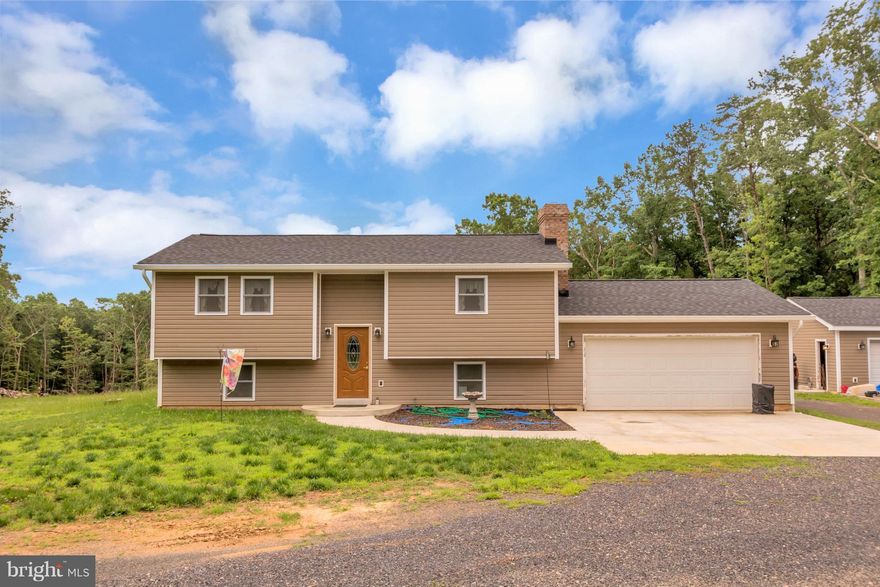Spacious split foyer on large 5 acre level lot.  4 garage spaces, 2 attached and 2 detached with circular drive way.  Huge concrete patio & tiered deck overlooking huge wooded back yard. Recent remodeling/updates, SS appliances & Hardwood floors throughout living area. Extra den w/ raised hearth wood stove. Lower level master/full bath.