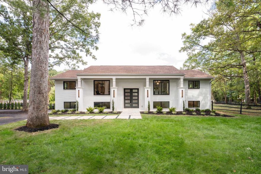 A MM Design Co Project -  Fully Redeveloped Luxury Waterfront Living on 1-Acre Flat Lot with over 200 ft of waterfront  in Lake Barcroft. Welcome to 6211 Waterway Drive, a rare and stunning waterfront retreat in Falls Church’s coveted Lake Barcroft community. Situated on nearly an acre of flat landscaped grounds with private lake access and a new dock, Featuring six bedrooms, three bathrooms, 2 car garage, new boat dock, and nearly 3,900 square feet of meticulously crafted living space with panoramic views of one of Northern Virginia’s most exclusive private lakes.
The home makes a striking architectural statement with newly installed 8-foot modern double entry doors, four sleek stucco columns, and a new concrete walkway framed by fresh landscaping and modern lighting. Inside lake views greet you in a space that blends clean, contemporary design with luxurious finishes.
At the heart of the home is the open-concept chef’s kitchen—ideal for culinary pursuits and effortless entertaining. Centered around an 11-foot island with gleaming  quartz countertops, it includes a 48” professional gas range, inlay custom cabinetry with full-height pantry storage, and handcrafted tile surrounding a custom vent hood. This space is flooded with natural light and sweeping lake views.
Both levels feature new wide-plank warm oak engineered hardwood floors, recessed and statement lighting. Expansive Sierra Pacific windows and a new glass slider frame picturesque water views from multiple rooms.
The lake-view primary suite is a serene escape with custom walk-in closets and a spa-inspired ensuite featuring a quartz-topped vanity, frame-less glass rainfall shower, and sophisticated Zelliege tile. Secondary bedrooms are spacious and adaptable for guests, home offices, or a gym—all with views. Bathrooms throughout maintain the home’s refined modern aesthetic, with stylish vanities, warm finishes, and thoughtful layouts.
Every detail has been elevated—from modern interior doors and hardware to updated baseboards and trim. The oversized two-car attached garage offers convenience and storage.  Outdoor living is equally impressive. A large Trex deck with sleek railings provides a seamless extension of the indoor space—perfect for morning coffee, evening cocktails, or al fresco dining. Below, a stamped concrete patio offers additional entertaining space, while the fully fenced backyard ensures privacy. Step down to the dock for direct access to Lake Barcroft’s 135 acres of water—ideal for boating, swimming, and fishing.
Lake Barcroft is a unique enclave known for its close-knit community, five private beaches, and peaceful setting—just minutes from Washington, D.C., Arlington, Tysons, and major commuter routes. Homes of this caliber, on flat lots with direct lake frontage, are exceptionally rare.