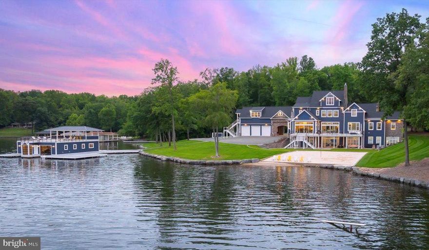 Celebrated as the finest estate on the lake, this luxurious waterfront masterpiece stands as a legacy to luxury and lakeside grandeur, setting the standard for waterfront living at Lake Anna, Virginia.  Nestled on the widest and most exclusive section of the lake on the public side, this awe-inspiring estate has been meticulously renovated to showcase the highest quality craftsmanship and comes fully furnished.  Encompassing 11,000 square feet, the estate features 7 bedrooms, 7 full bathrooms, and 4 half-baths, all on a secluded 2.17-acre lot, offering a rare combination of architectural sophistication, expansive amenities, and breathtaking views that define premier lakefront living, without the constraints of an HOA. Inside the main home, you'll find 6 spacious bedroom suites, each with its own private bathroom. The gourmet kitchen is equipped with high-end stainless steel appliances, a 6-burner gas stove, smooth quarts countertops, pendent lights above the massive island, and a large walk-in pantry with custom shelving. The oversized primary bedroom suite is conveniently located on the main level and features its own private living room or home office with a fireplace, private access to the large deck overlooking the water, two large walk-in closets, and a luxurious ensuite bathroom with a stand-alone tub, dual vanities, a separate tiled shower, and a private water closet.  Enjoy multiple expansive living areas, including a family room with panoramic lake views, a living room off the kitchen and a fourth-floor lounge complete with a full wet bar and half bathroom. The massive, finished walkout lower level, offers a family room, recreation area, game space, full bar for entertaining, a bedroom with its own private bath, a workout room, half bath and multiple storage rooms. Connected to the main house by a beautiful breezeway is a private apartment located above the garage, featuring a bedroom, living room, kitchenette, and full bath—perfect for guests or extended family. Step outside to enjoy an expansive deck and patio that overlook the perfectly manicured yard (featuring turf grass) and a sandy beach where children can play or build sandcastles. For recreation, there’s also a private basketball and tennis court. Down at the water, spend sunny days on your private sandy beach with a volleyball net, or enjoy the deep-water boathouse with composite decking, two covered slips with electric lifts, a spacious upper-level sun deck with a covered area that has cabinets and countertops for entertaining, and there is also a double jet ski pad (14+ feet water depth at the boathouse). With over 1,100 feet of prime shoreline secured by boulder-sized riprap stones and multiple docks for guests, this estate is perfectly suited for both relaxation and entertaining. Additional features include a hot tub, fire pit, geothermal heating and cooling, a circular driveway, and a lake-fed irrigation system. Lake Anna was named the #1 “beach” vacation investment location in the entire nation by Fox Business, making this lakefront paradise not just a dream home but also an incredible investment opportunity. Located just a two-hour drive from Washington, D.C., this estate offers a serene retreat with endless recreation and fun for everyone! For those seeking waterfront living at its finest, we offer a private paradise on Lake Anna where you can become part of the legacy of owning this premier estate.