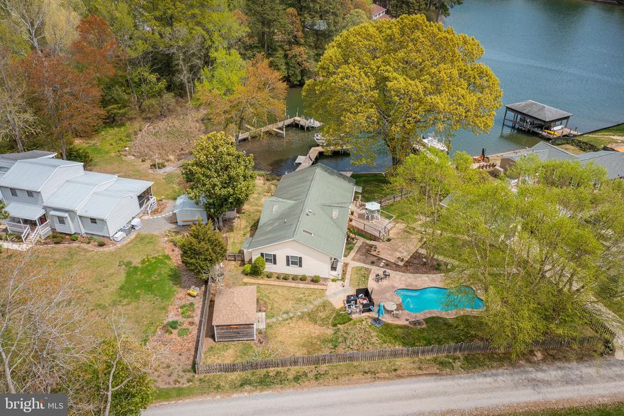 Waterfront Living on Whay’s Creek with Pool, Dock & Detached Office!  Beautifully updated 3‑bedroom, 2‑bath home with exceptional outdoor amenities and 3’ MLW on Whay’s Creek. Enjoy a waterside screened porch, heated saltwater pool and dock with boat lift. The remodeled kitchen features granite counters, gas cooking, and a center island, opening to a bright living/dining area with gas fireplace and creek views. The primary bedroom includes a renovated bath with walk‑in tile shower, complemented by two additional bedrooms and an updated hall bath. A bonus craft room and a mudroom with storage and second fridge add great functionality. The property includes a detached office with power, internet, and heating/cooling, a 1.5‑car garage, garden shed, fenced front yard, and landscaped grounds with perennials and birch trees. Flood Zone X and STR‑friendly