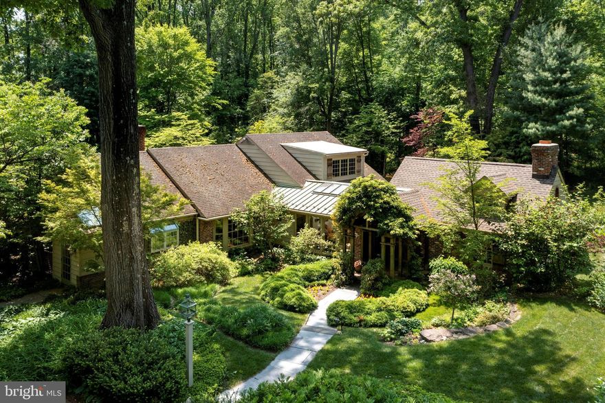 Expanded Cape tucked away on award winning arboretum like grounds in a highly desirable Whitemarsh Township neighborhood. The washed brick and cedar exterior blends with the exciting elements of the interior, including an open floor plan leading to spacious rooms, vaulted ceilings, main floor primary bedroom suite and several walls of windows providing streaming sunlight and panoramic views of the jaw dropping exterior grounds. A special property that truly offers indoor/outdoor living surrounded by an abundance of nature. 
The long, circular drive surrounded by perennial gardens and heritage trees leads to flagstone walkways to covered front door entry. The entrance foyer with slate floors provides a tantalizing view of the stunning and spacious Great Room addition featuring soaring ceiling, radiant floor heat, architectural barn trusses, large wood burning fireplace flanked by custom built-ins and oversized windows providing breathtaking views of the exceptional grounds. The connecting Dining and Family Rooms also feature fireplaces and both rooms feature French doors to enchanting patios and ease of flow to the hub of the home, the Kitchen. Cooking and entertaining are a delight in the kitchen featuring added convivences such as long island, plenty of cabinetry, fine appliances and double sinks.  The kitchen has side mudroom entrance and also opens to charming family room with dramatic vaulted ceilings, fireplace and neat overlook loft. The main floor also includes the Main Bedroom Suite wing with spacious bathroom including iron cast soaking tub, sky light, spacious walk in closet and separate study which could also serve as an additional bedroom. As a bonus, the Main Bedroom suite also features French doors leading to private flagstone patio. Also included on first floor: Butler's pantry with wet bar, beverage refrigerator and cabinetry - ideal for entertaining, breakfast room with oversized bay window, laundry room, mudroom off kitchen, main entry hall with exposed stone and more windows.
The second floor offers 3 spacious bedrooms, full bathroom with double vanity, numerous storage options and cozy loft with built in bookshelves overlooking the kitchen/family room area. The spacious upstairs layout offers endless opportunities to adjust living spaces, etc. 
There is a partially finished Basement which includes a fitness area, workshop and mechanical room. In addition to the outstanding landscape, the exterio  features a Two Car detached Garage and the most wonderful Gazebo tucked in the gardens. The location and exterior grounds are unparallel. The architecture masterfully blends the indoors to outdoors with many entrance ways, flagstone patios, covered verandahs and trellises. The inground swimming pool is a complete sanctuary surrounded by lovely specimen trees, perennials and accessed over wooden bridge walkway. 
Property is located minutes to major arteries, 2 train stations, bustling town of Ambler, Germantown Academy campus & numerous connecting trails including Green ribbon and Wissahickon Trails.