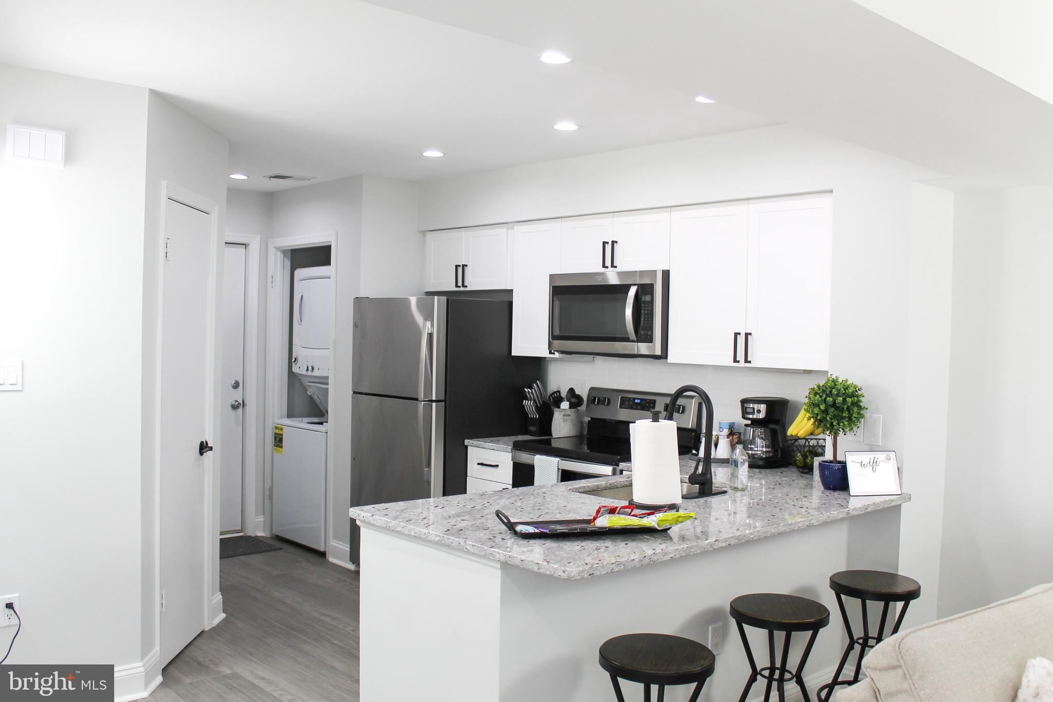 Discover modern condo living at its finest in this beautifully updated two-bedroom, one-bathroom home that proves good things really do come in perfectly designed packages. This main-level gem features two bedrooms positioned at opposite ends for maximum privacy – because everyone deserves their own sanctuary.
The heart of this home showcases an open concept design where the kitchen flows seamlessly into the combined living and dining area. Stainless steel appliances and granite countertops add that chef-worthy touch, while the primary bedroom boasts large windows that flood the space with natural light. The contemporary bathroom features modern fixtures that make your morning routine feel like a spa experience.
Step outside to your private patio – the perfect spot for morning coffee or evening relaxation. Inside conveniences include in-unit laundry facilities, because who has time for laundromat adventures?
Parking is a breeze with a one-car garage plus an additional driveway space, totaling room for up to three vehicles when you include the visitor pass system. The garage sits conveniently at the rear of the building.
This Silver Spring location puts you within easy reach of Maryland-National Capital Park for outdoor recreation, quality schools like Springbrook High School, and convenient shopping at Trader Joe's. Public transportation options keep you connected to the broader area.
Whether you're seeking a comfortable home or exploring rental income potential, this turnkey property delivers modern amenities in a prime location. The thoughtful layout and quality finishes create a space that's move-in ready and perfectly positioned for contemporary living. Call helpful agent for more info!
