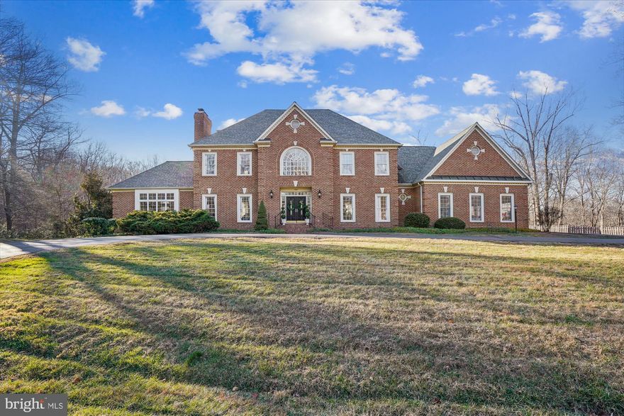 Tucked away on a quiet cul-de-sac, this timeless brick colonial offers a rare blend of privacy and community on approximately 6.5 acres in Clifton, one of Northern Virginia’s most coveted neighborhoods. Surrounded by mature woods, the backyard features a private fishing pond with a fountain, an expansive deck and in-ground pool, perfect for entertaining.  Peaceful views abound in every direction—yet it’s less than five minutes from Main Street Clifton, Paradise Springs Winery, and Hemlock Overlook Regional Park.
Inside, the home offers four bedrooms and four-and-a-half baths with thoughtful updates throughout. Upstairs bathrooms are completely renovated, and the kitchen gleams with refreshed cabinets and brand new appliances. Hardwood floors span the main living areas, complemented by fresh interior paint and new light fixtures throughout. Five fireplaces add warmth and elegance to every level. The large main-level office provides an ideal work-from-home retreat. A four-car garage completes the package, providing ample space for vehicles, storage, or hobbies.
Many additional updates add peace of mind, including a new lower level HVAC in 2025 and new water heater, well treatment system and pool filter in 2024.  
The town of Clifton is prized for its uniquely charming small-town lifestyle with year-round community events, parades, and holiday celebrations that bring neighbors together and preserve the town’s historic character. This exceptional home in the heart of Clifton is an uncommon opportunity and a must-see for buyers in the luxury home market.