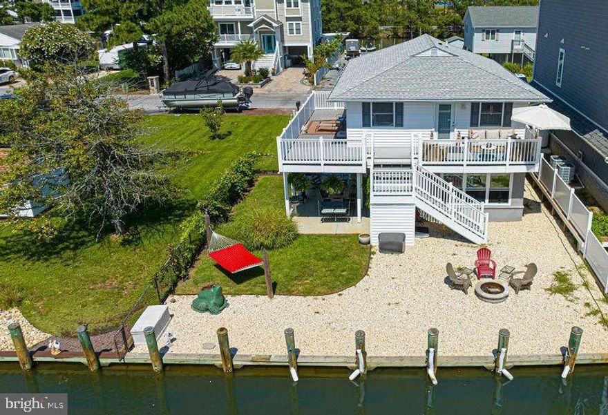 Make Snug Harbor your next Waterfront home!   Deep water boat dockage with direct access to the Sinepuxent Bay and NO HOA fees!  Just a short drive to the beaches of Ocean City or Assateague Island National Seashore.  Totally updated and turn-key.  New roof in 2020, upgraded electric, replacement windows, 5 Ductless Mini-Split HVAC  units.  Upper level features 2 Bedrooms, Hardwood Floors,  Stainless Steel Appliances, Granite Countertop, and access to an extra large wrap-around Trek Deck with Vinyl Railings.  Lower level includes a separate income-producing  apartment with full kitchen, laundry, separate bedroom, bath, and spacious waterfront  Sun Room.  Currently rented for $1200/month.  The 24x15 covered Lanai is the perfect spot for relaxation or entertaining guests.   Don't delay taking advantage of this unique  opportunity with  low traffic and beautiful neighborhood homes in a  peaceful location.