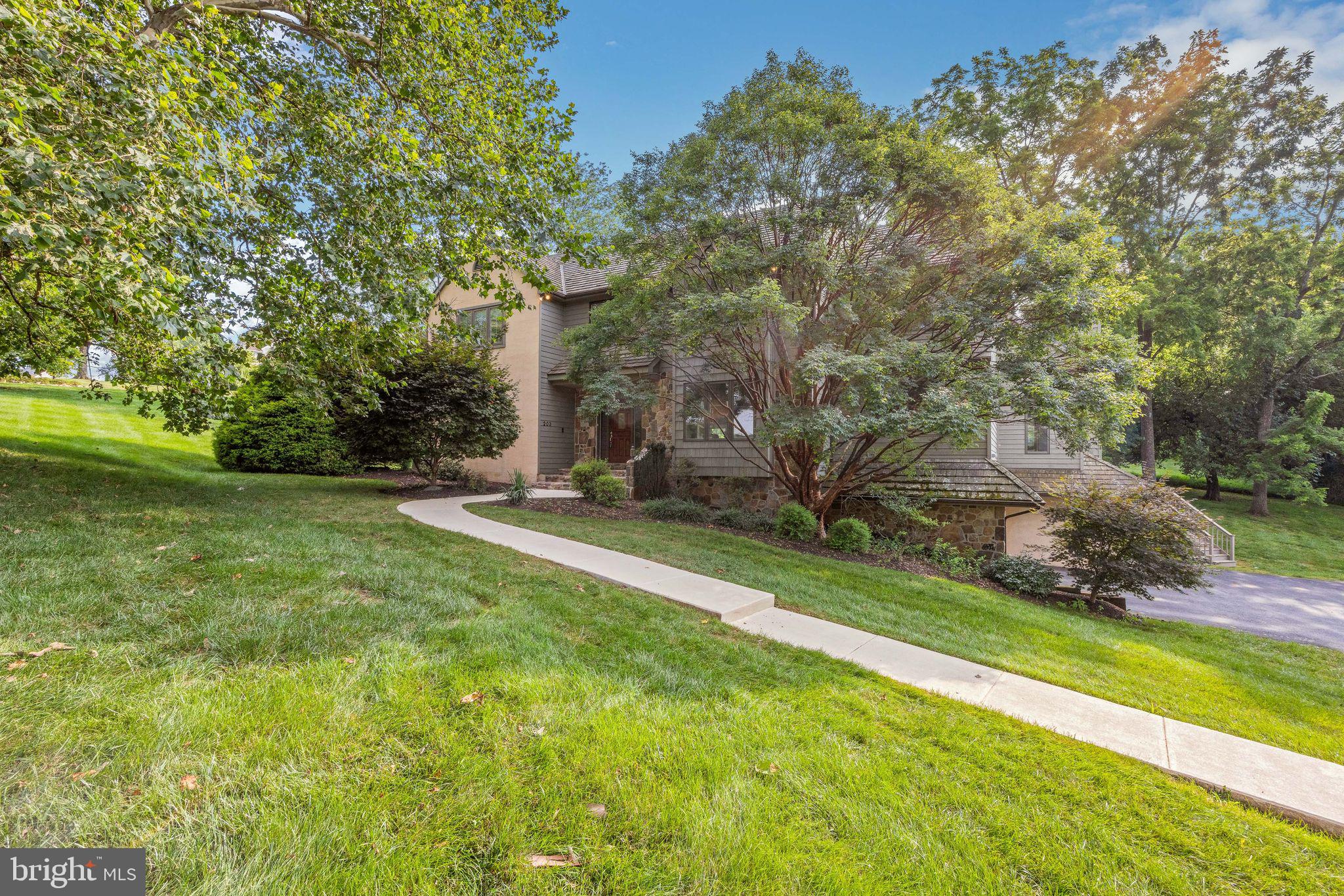 Welcome to 203 Barn Hill Road – Where Timeless Elegance Meets Everyday Comfort
Nestled in the sought-after and prestigious Blue Rock Meadows community, just minutes from the heart of historic West Chester Borough, this exceptional custom-built four-bedroom, 2.5-bath residence offers the rare blend of privacy, convenience, and unparalleled livability. Set on a beautifully landscaped one-acre lot in scenic East Bradford Township, the home is a private retreat designed for both quiet relaxation and gracious entertaining.
From the moment you arrive, the curb appeal is undeniable. A handsome stone and clapboard exterior, cedar shake roof, and a gently curving drive with ample guest parking set the tone for what’s to come. The attached three-car garage provides effortless entry and convenience, while a classic formal walkway welcomes you into the front foyer.
Inside, the home’s warmth and craftsmanship shine. Soaring cathedral ceilings, operable skylights, hardwood floors, and a stunning raised-hearth fireplace create a sense of airiness and comfort in the living room, where natural light pours through oversized windows framing serene backyard views.
To the left, a spacious home office with built-in shelving provides the perfect environment for remote work or study. A flexible den nearby offers endless possibilities—it has served as a music studio, exercise room, second office, and media lounge, adapting seamlessly to any lifestyle.
To the right of the foyer, a formal dining room with box-bay window and hardwood floors is perfectly sized for hosting holiday dinners and celebrations. The adjacent updated kitchen is a true showstopper, outfitted with abundant white cabinetry, a large center island, a newer refrigerator, and a massive walk-in pantry to keep everything beautifully organized. For the home chef, the gas range with downdraft vent makes cooking a joy—form and function in perfect harmony.
Open to the kitchen is the inviting breakfast room, where you can sip your morning coffee while overlooking the expansive deck and backyard. A cozy family room flows from the kitchen, featuring a second stone fireplace—ideal for relaxed evenings and casual get-togethers.
The main-level laundry room is generously sized with extra cabinetry for storage, and a well-placed powder room completes the first floor.
Upstairs, the primary suite is a private sanctuary. The spacious bedroom includes a charming window seat with hidden laundry chute, dual walk-in closets, and a spa-inspired ensuite bath with dual vanities, walk-in shower, soaking tub, tile flooring, and private water closet.
Three additional bedrooms—each with double closets—are located down the hall, along with a large hall bathroom featuring dual sinks and a tub/shower combination, perfect for guests or family.
The finished walk-out lower level adds tremendous value and flexibility, with a bright recreation room, a door to the patio and backyard, and interior access to the three-car garage. A separate finished room makes a perfect craft room, home gym, or second office, and there’s a large unfinished area for storage, complete with the home’s mechanical systems, whole house generator, and surge protection.
Step outside to your personal oasis. The backyard is a perfect mix of lush lawn and mature trees, creating a private, peaceful setting for outdoor dining, gardening, or play. The deck is ideal for entertaining, grilling, or simply unwinding while watching the sunset over your tranquil property.
Location is everything—and here, you truly have it all. Just minutes from vibrant downtown West Chester, enjoy a wealth of nearby restaurants, shops, parks, top-rated schools, and cultural attractions, all while savoring the peace and beauty of this premier neighborhood.
Whether you’re looking to entertain with style, relax in comfort, or enjoy the very best of Chester County living, 203 Barn Hill Road is a place to live, love, and truly call home.